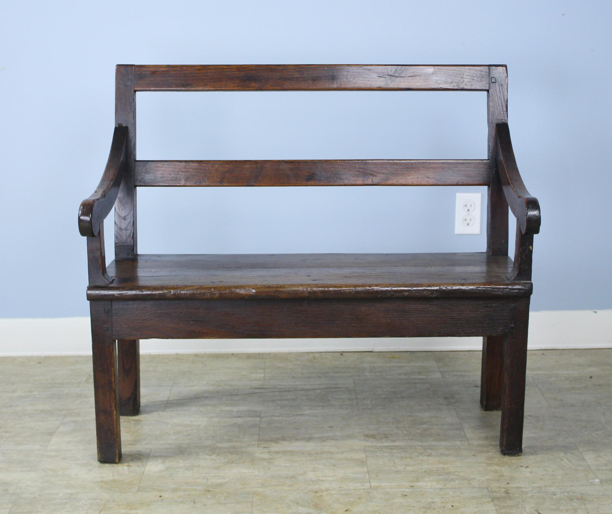 Sweet fireside bench from 19th century, France. Charming rustic look, practical for storage (originally for firewood). Really good chunky look, lovely carved arms.