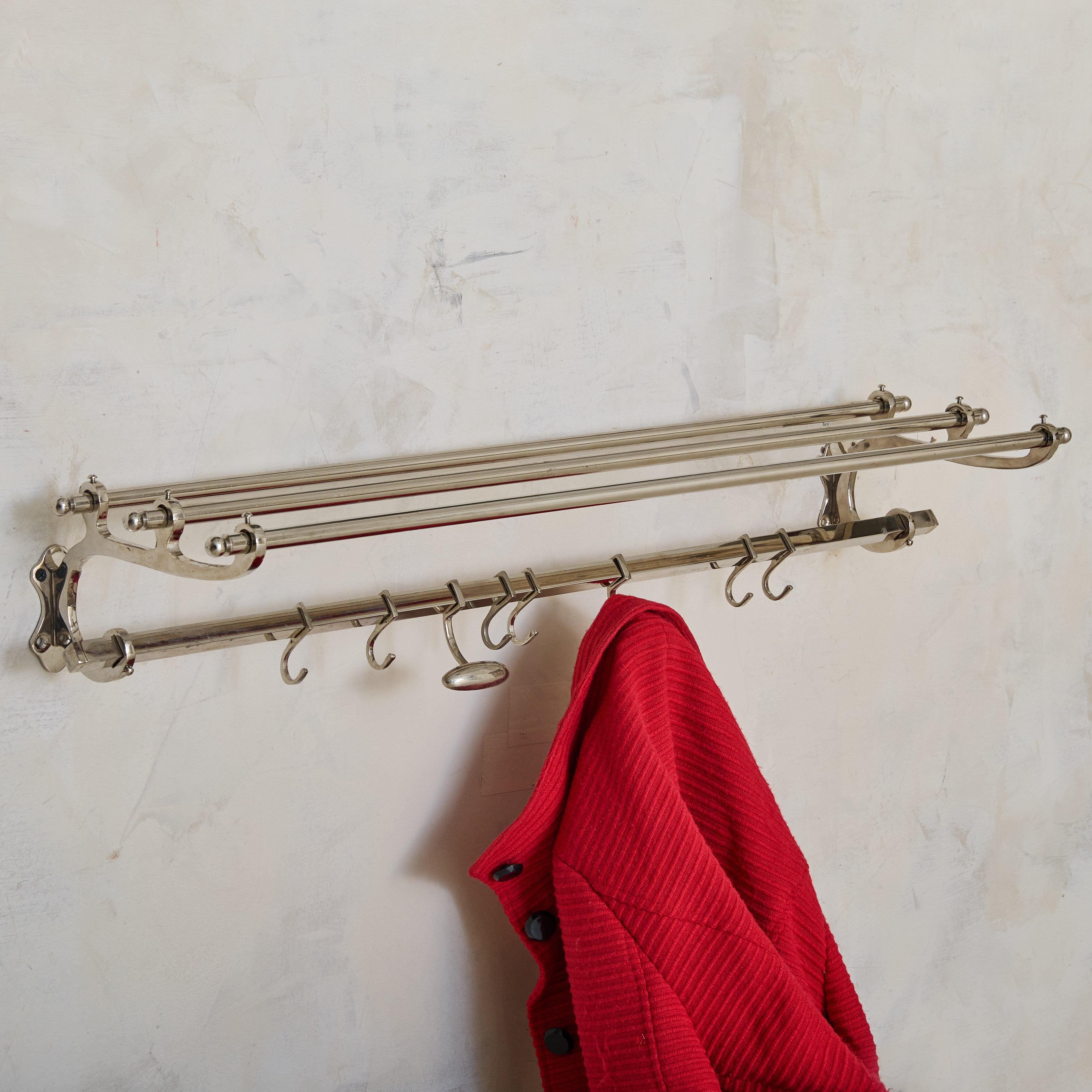 Un appendiabiti da parete francese degli anni '70, definito dalla sua forma elegante e minimalista. Realizzato in cromo, il pezzo presenta un ripiano a doppio binario per riporre cappelli o indumenti piegati, completato da una fila di ganci di varie