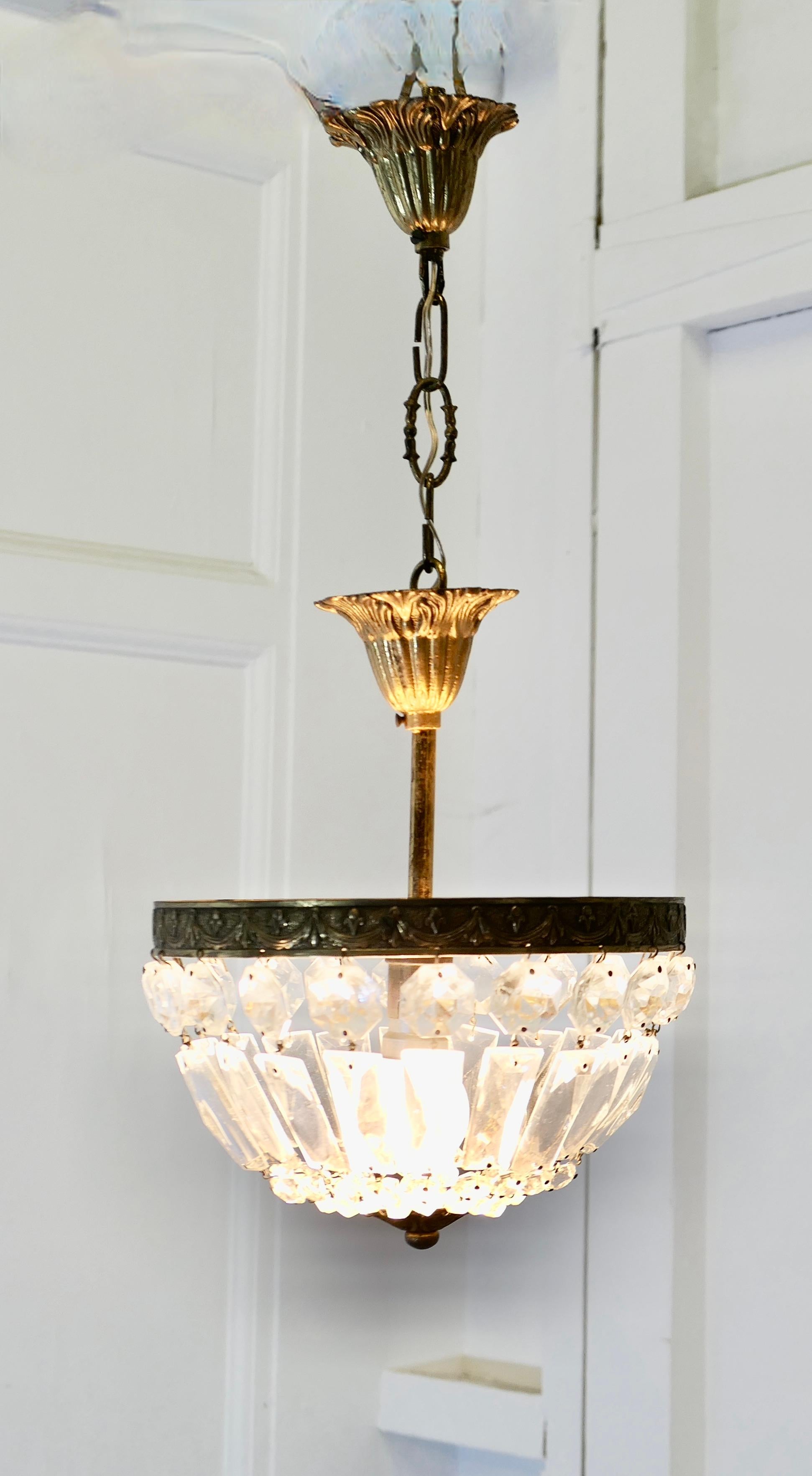 Piccolo lampadario a cesto in stile impero francese

Si tratta di un pezzo molto grazioso, con una struttura decorativa in ottone invecchiato che si fissa al soffitto tramite una piccola rosa, una catena inferiore e una seconda rosa; il lampadario è