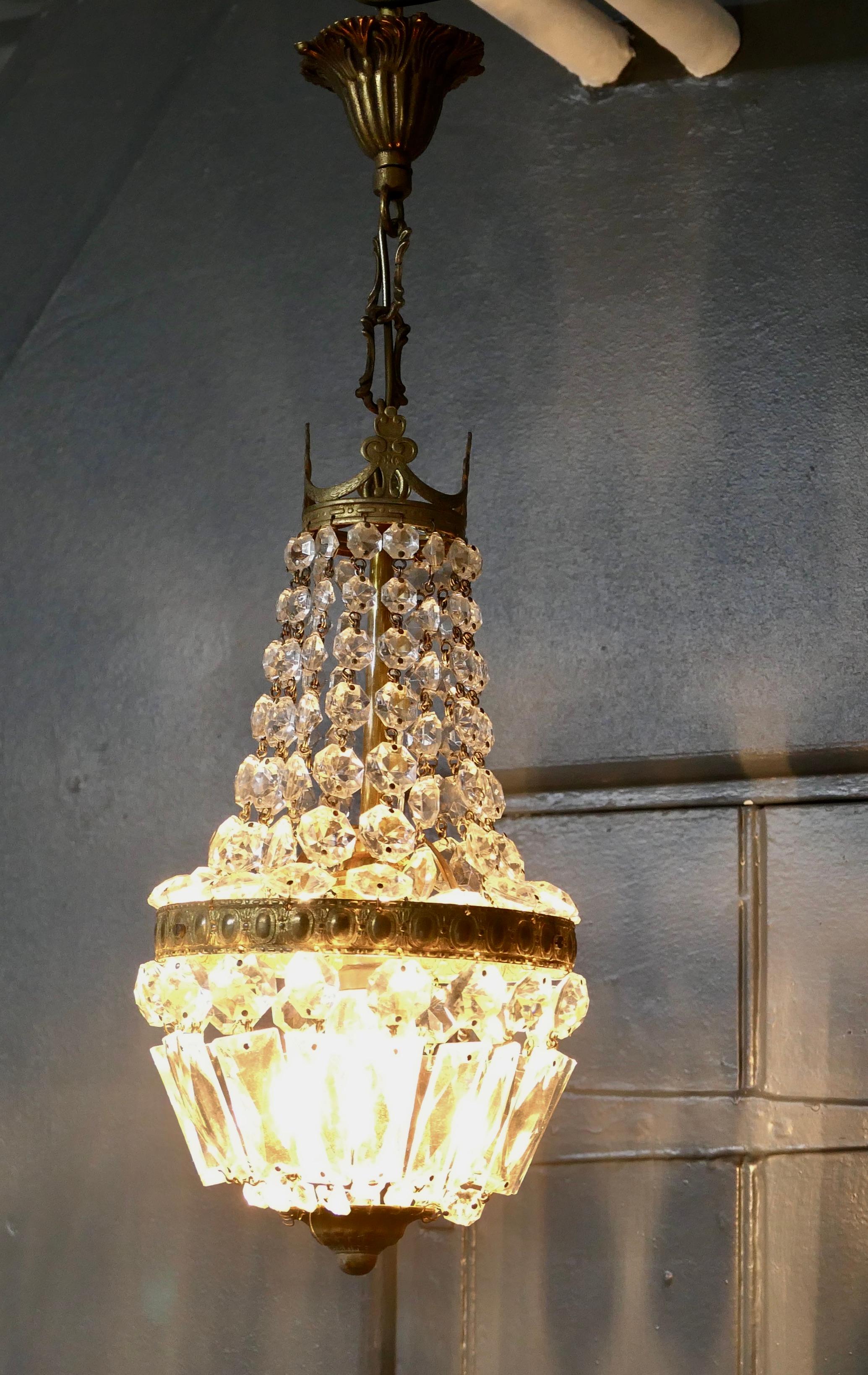 Small French empire style tent chandelier.

This is a lovely piece especially where a very large chandelier is not possible, it has an aged brass frame hung with chains of crystal beads, completed at the bottom with a basket of crystal