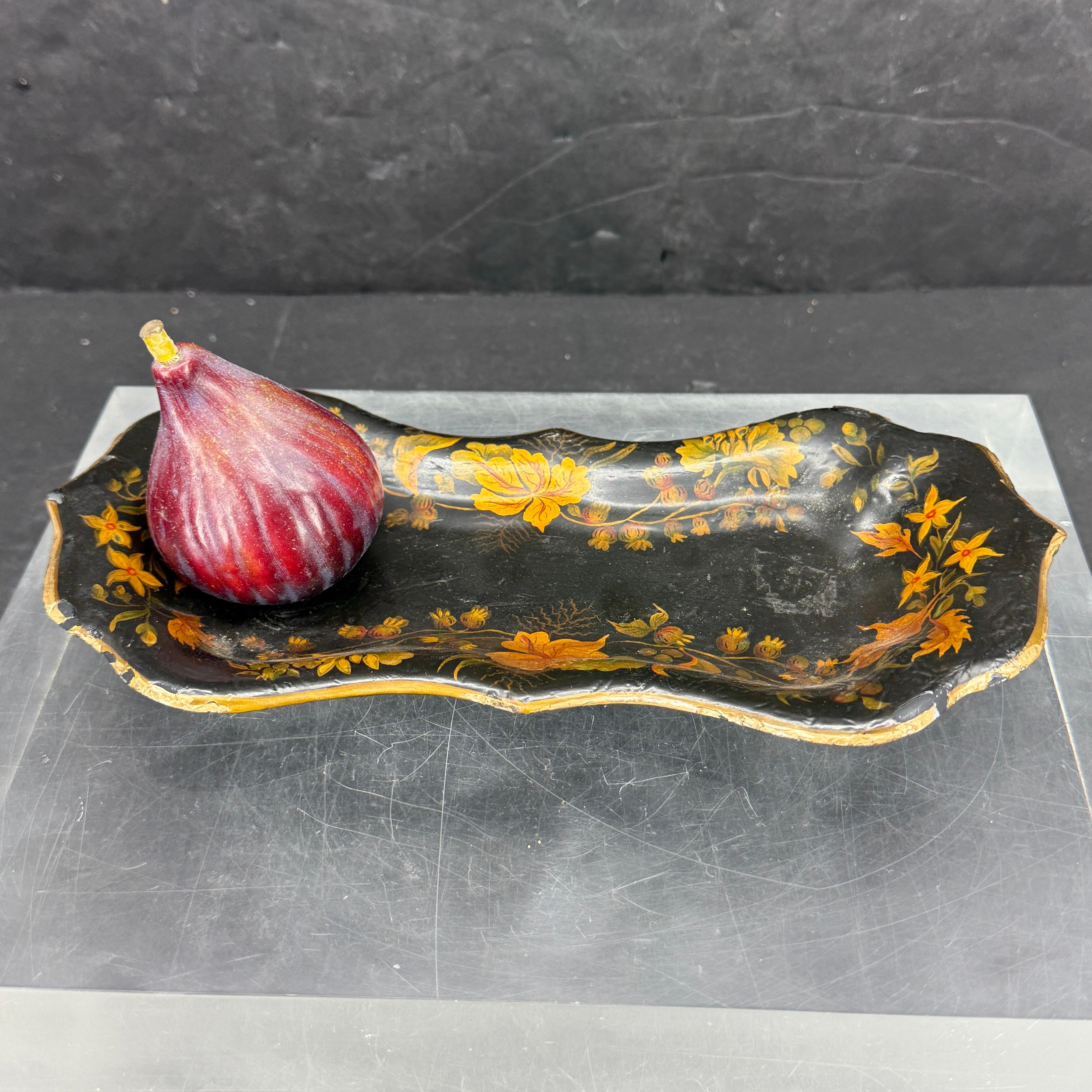 Pequeña bandeja francesa decorada en forma de mariposa con flores coloreadas a mano. Vemos esta versátil pieza en una mesa de cóctel o sobre un tocador para guardar tus joyas o baratijas favoritas. La parte posterior de la bandeja tiene la pintura