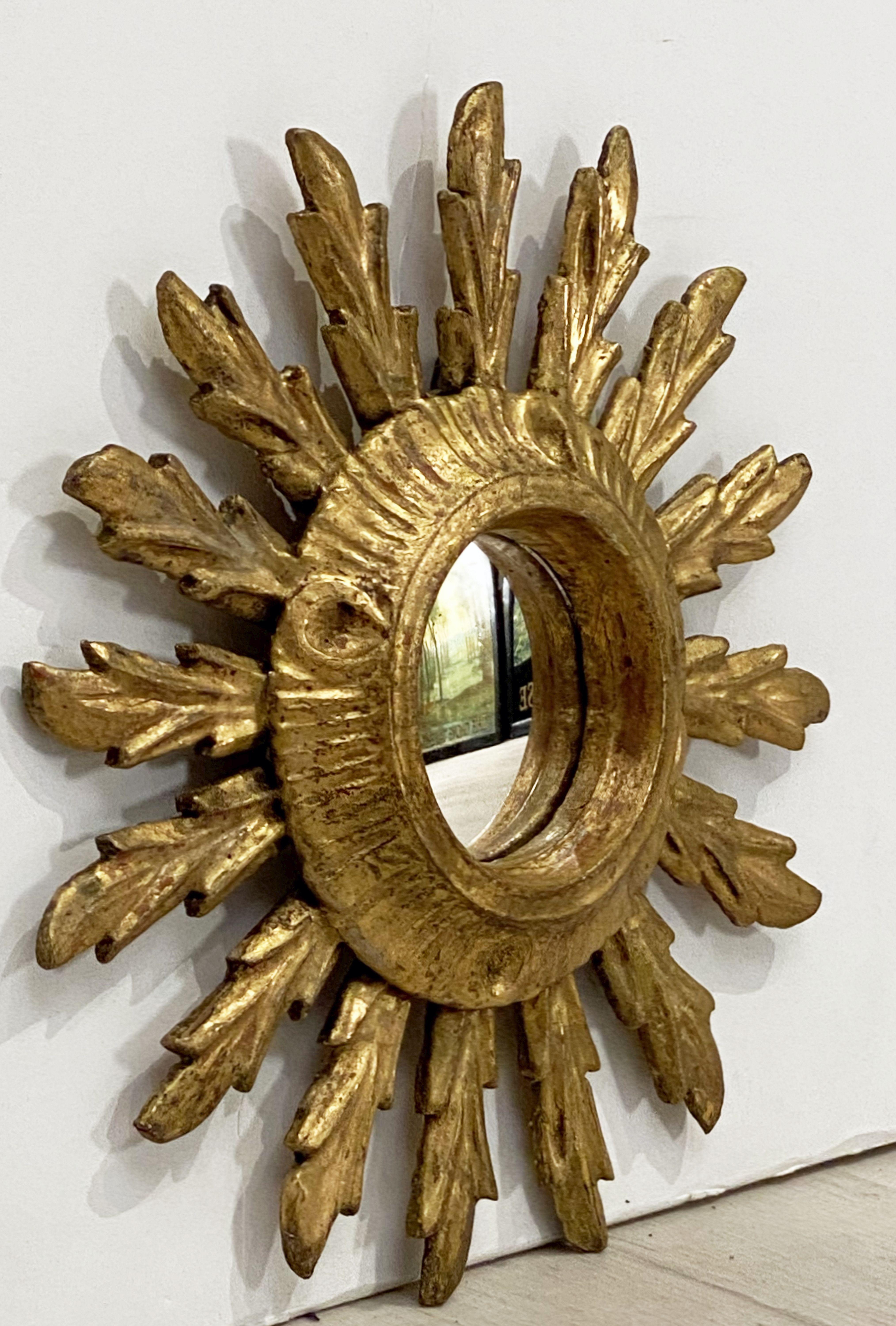 A lovely French gilt sunburst (or starburst) mirror with round convex mirrored glass center in moulded giltwood frame - the bright gilded rays resembling plumes of feathers.

Measures: Diameter of 9 1/2 inches.


 