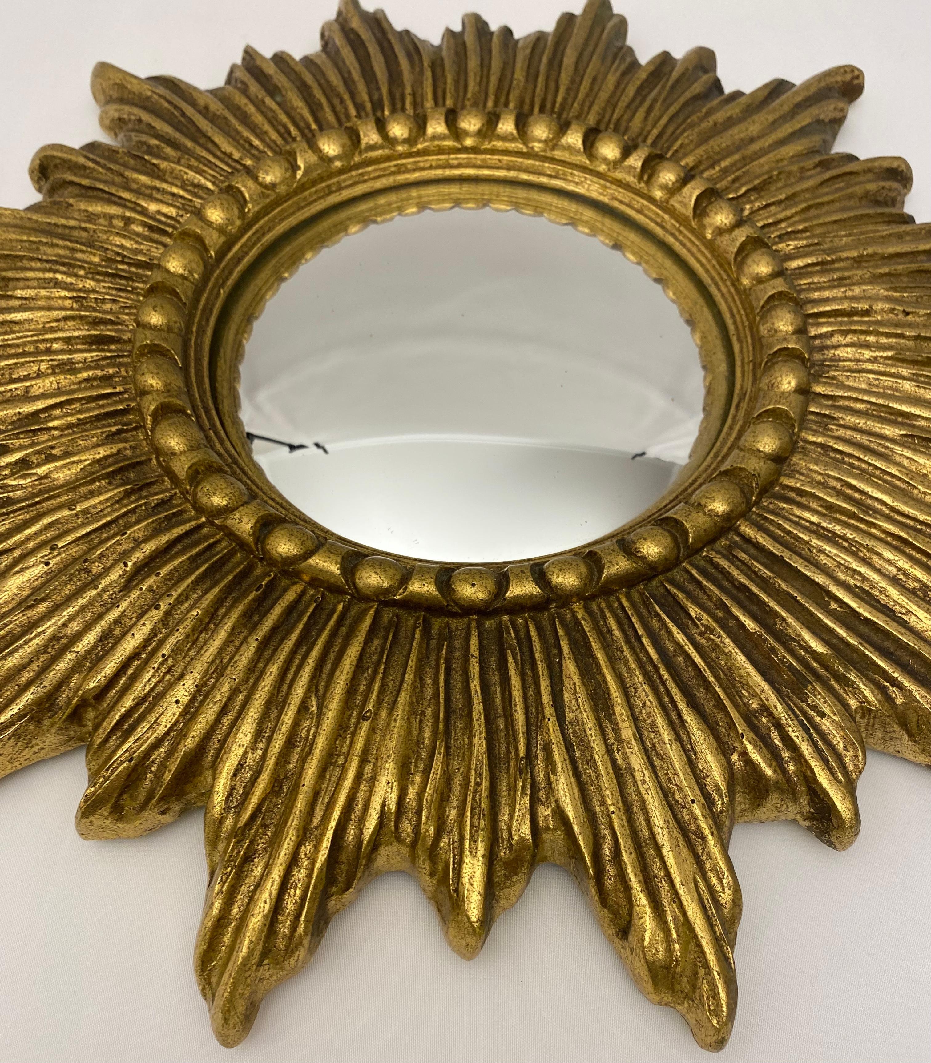 A lovely French gilt sunburst or starburst mirror with round convex mirrored glass center in moulded wood frame.

Measures: Diameter 14 inches x 1 1/8