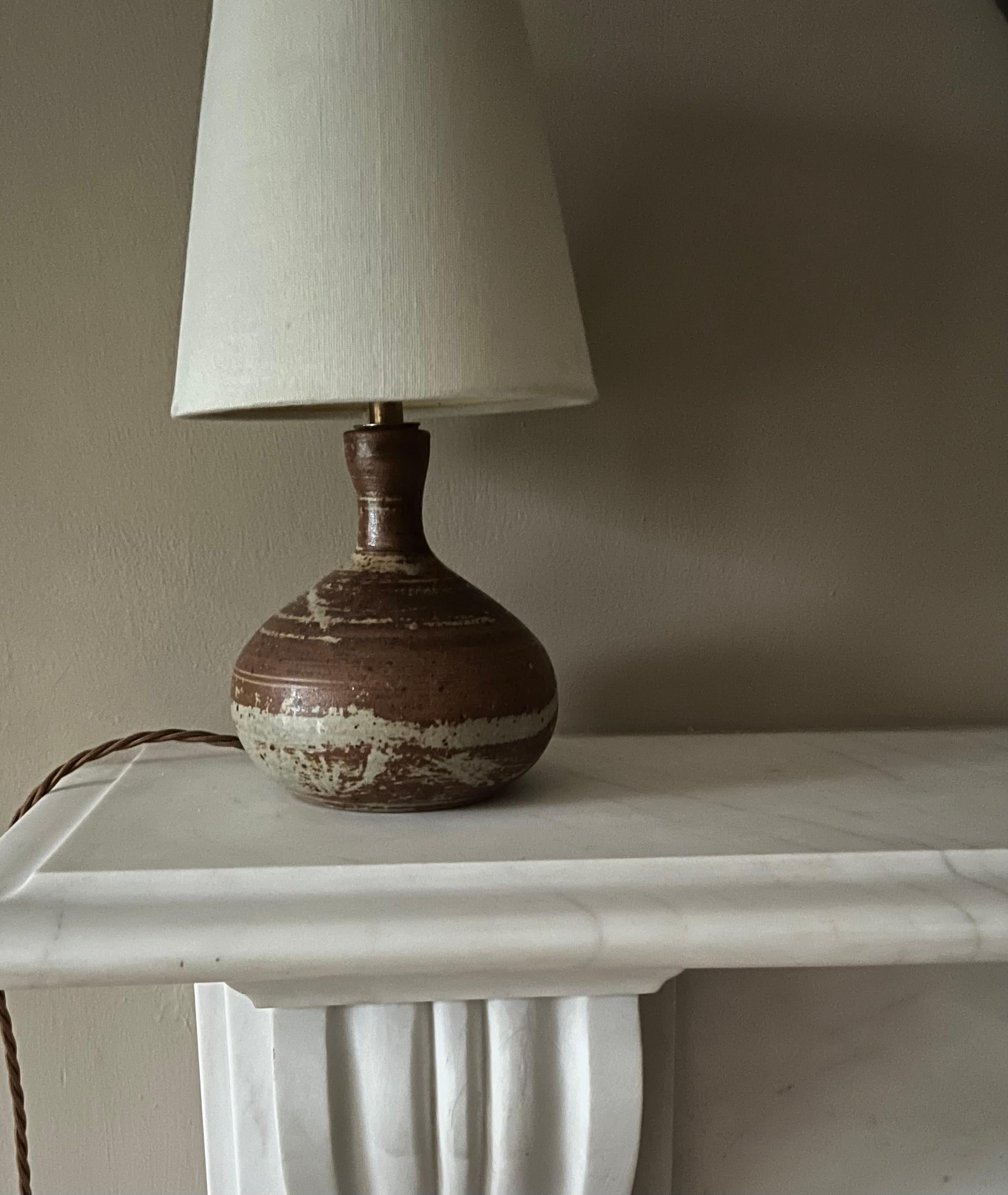 A pretty small French glazed ceramic lamp with indistinct signature to the base. Rewired with bronze silk flex.
