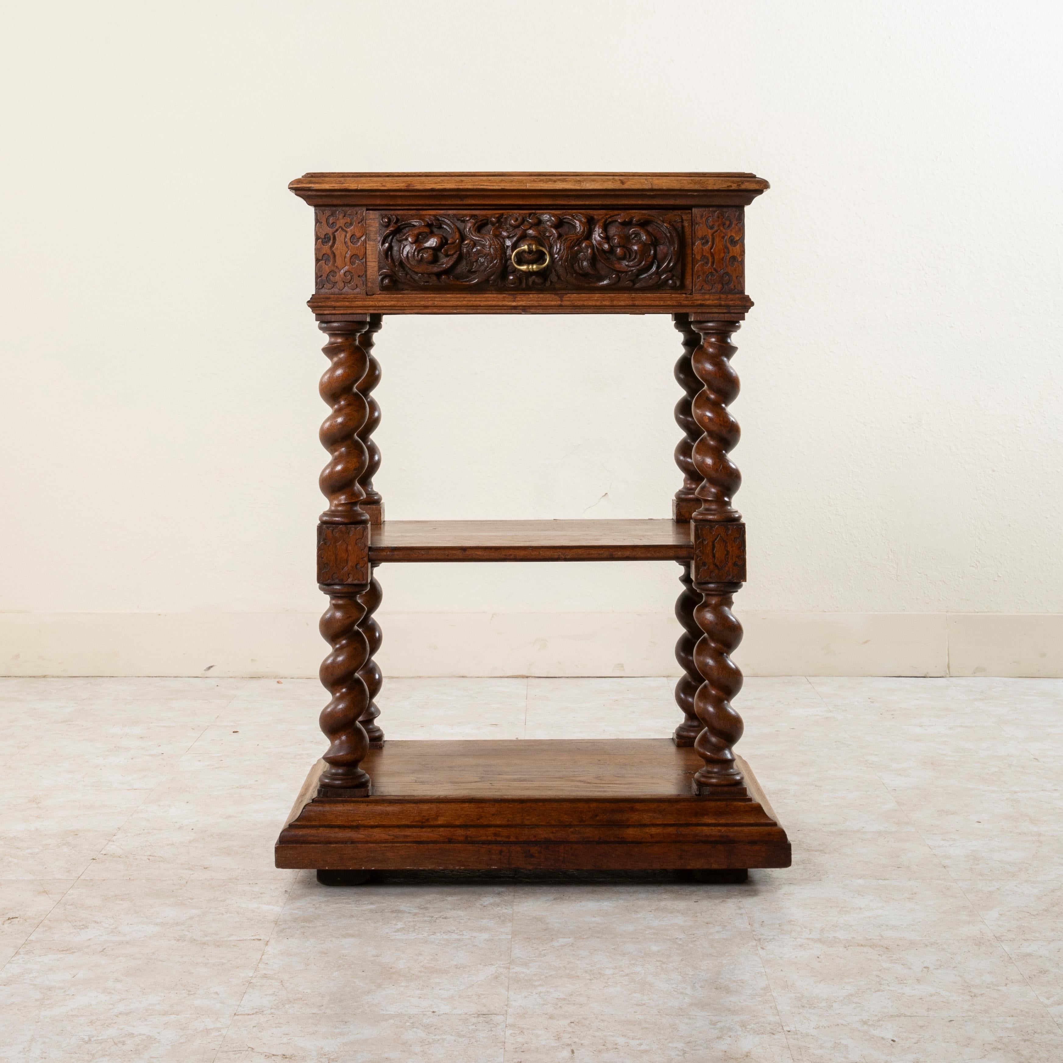 Questo piccolo buffet per dolci in quercia intagliata a mano in stile Luigi XIII, risalente alla fine del XIX secolo, presenta intagli su tre lati. I cartigli e le volute in bassorilievo ornano le giunture del dado. Il frontale del cassetto sotto il