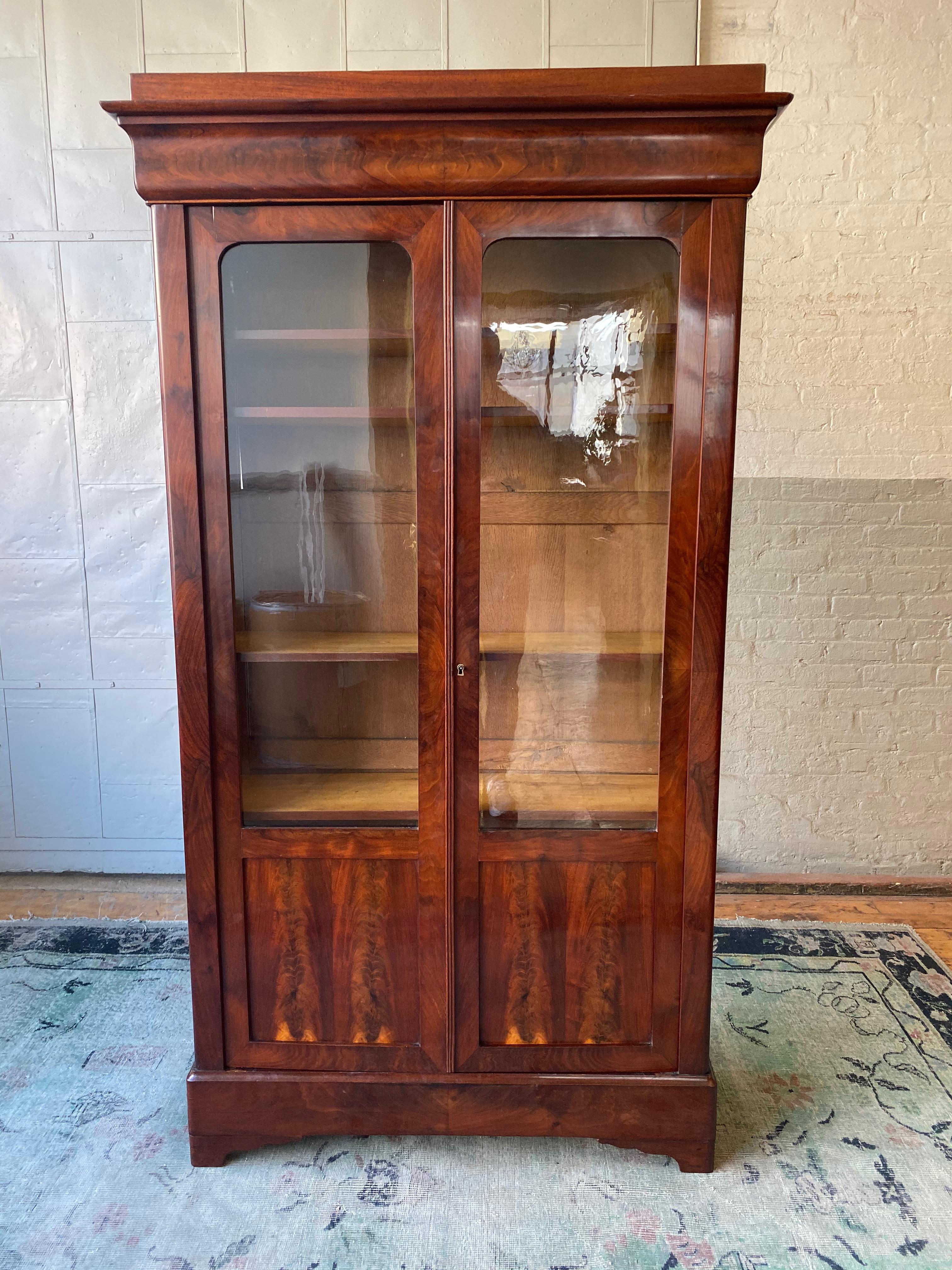 Small French Louis Philippe 19th century bookcase in mahogany veneers. The glass is original. The bookcase was recently polished is in very good condition.