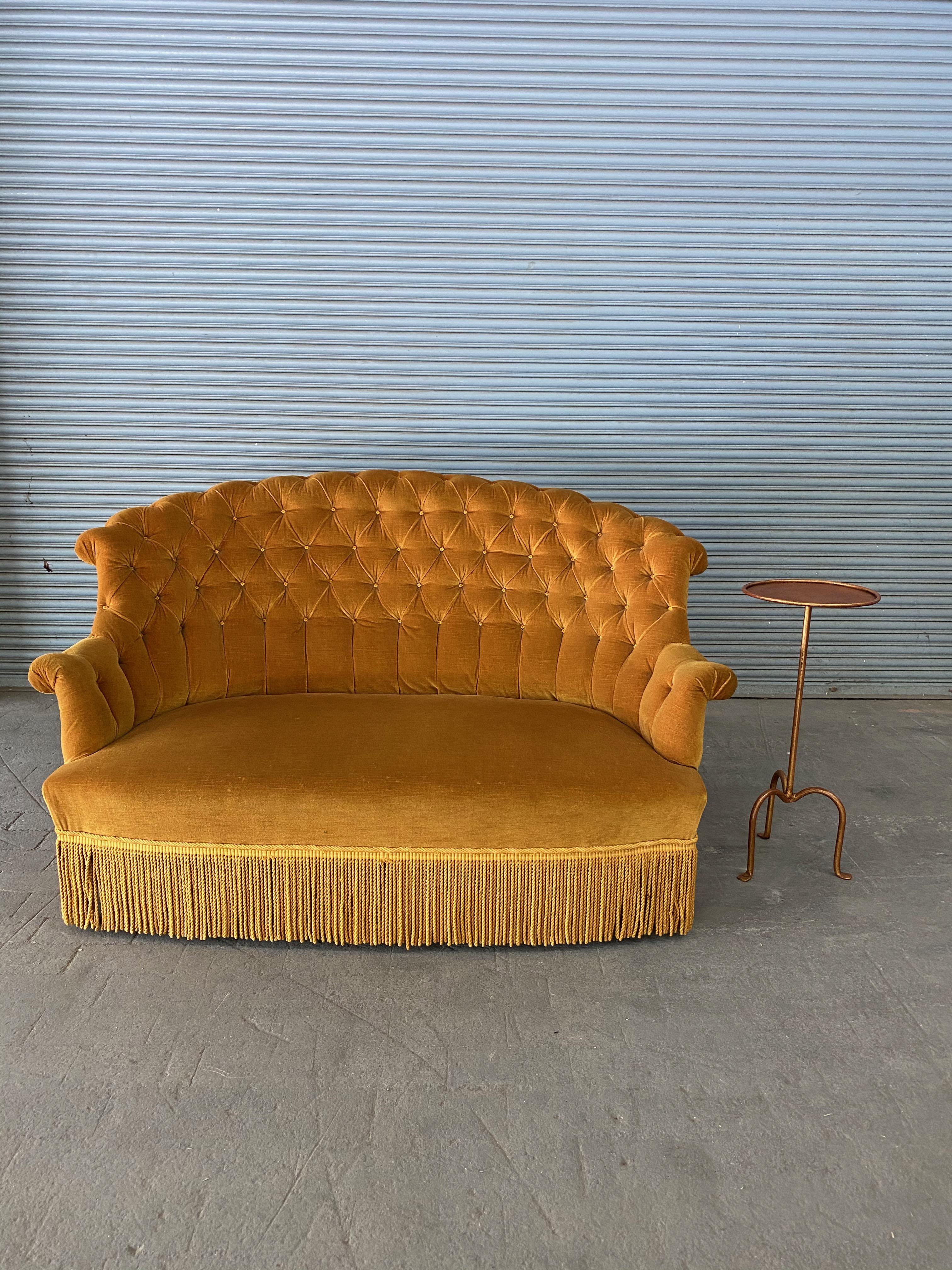 A French 19th century tufted settee upholstered in gold velvet. The settee / loveseat is in very good vintage condition, and while the upholstery is not new, the fabric is clean and can be used. Sold as is.

 
