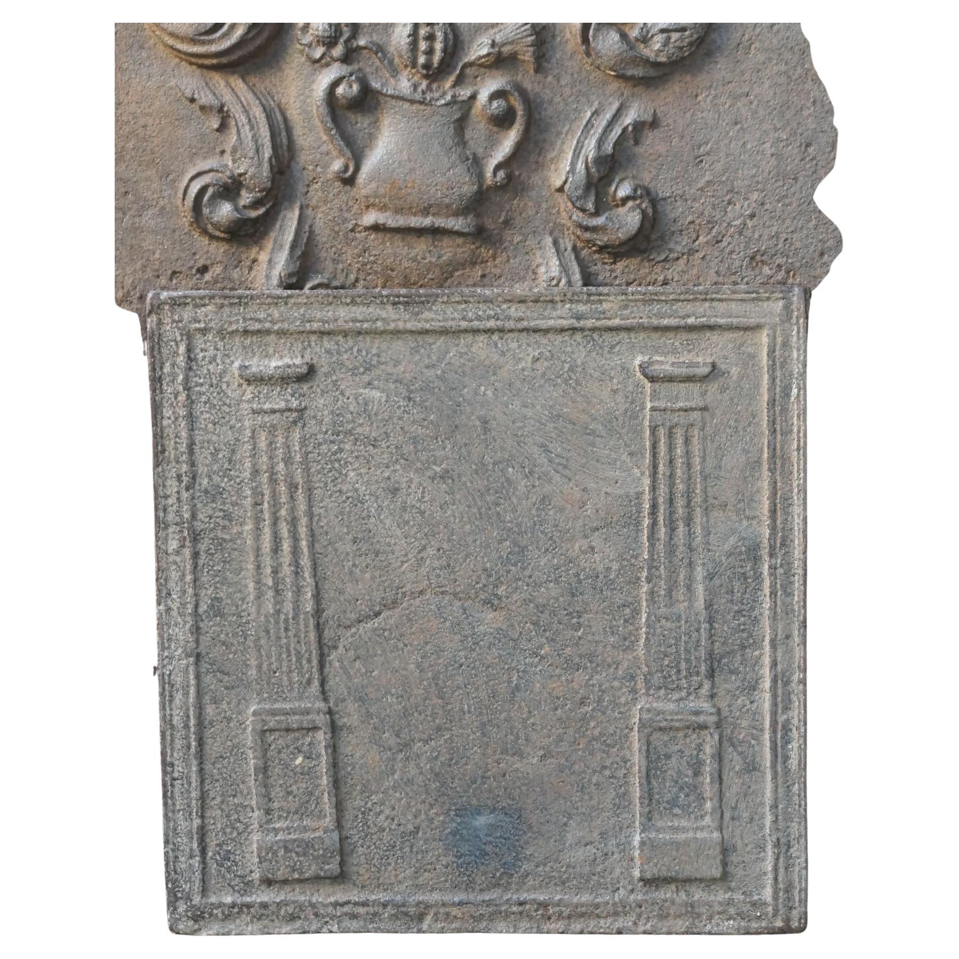 19th century French Neoclassical Period fireback with two pillars of freedom. The pillars symbolize the value of liberty, one of the three values of the French Revolution. 

The fireback is made of cast iron and has a natural brown patina. Upon