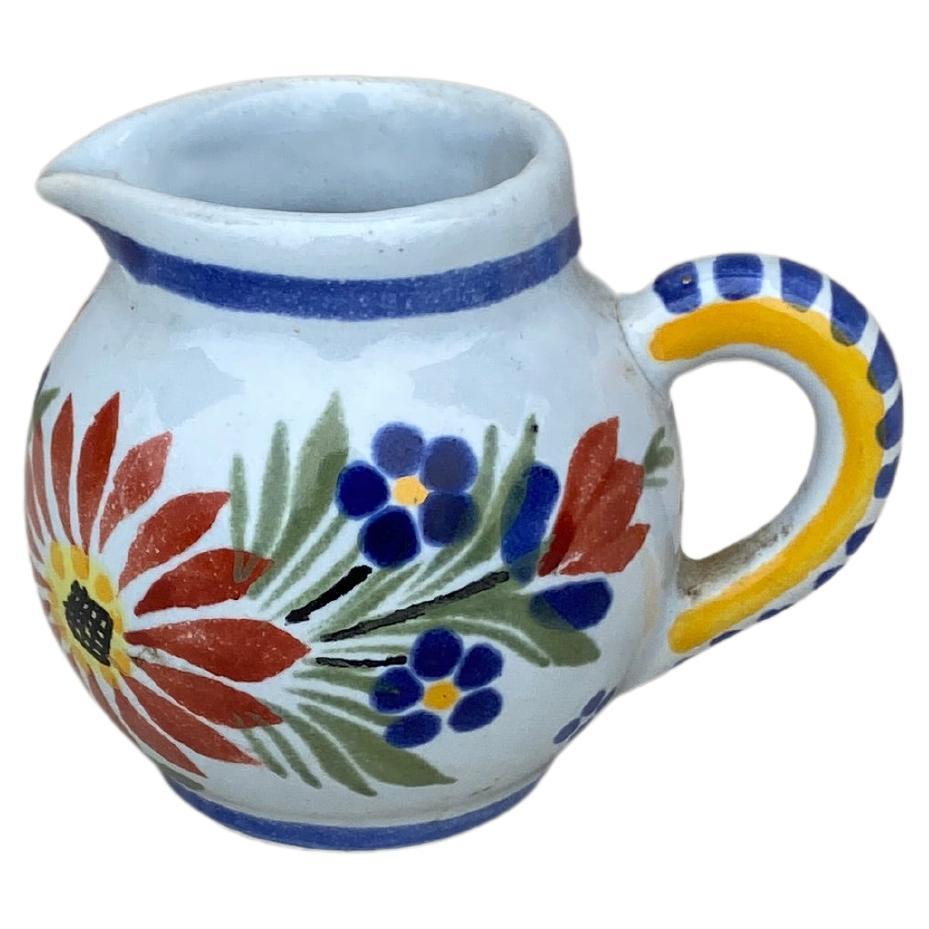 Small French faience pitcher painted with a floral pattern, circa 1940. Signed 