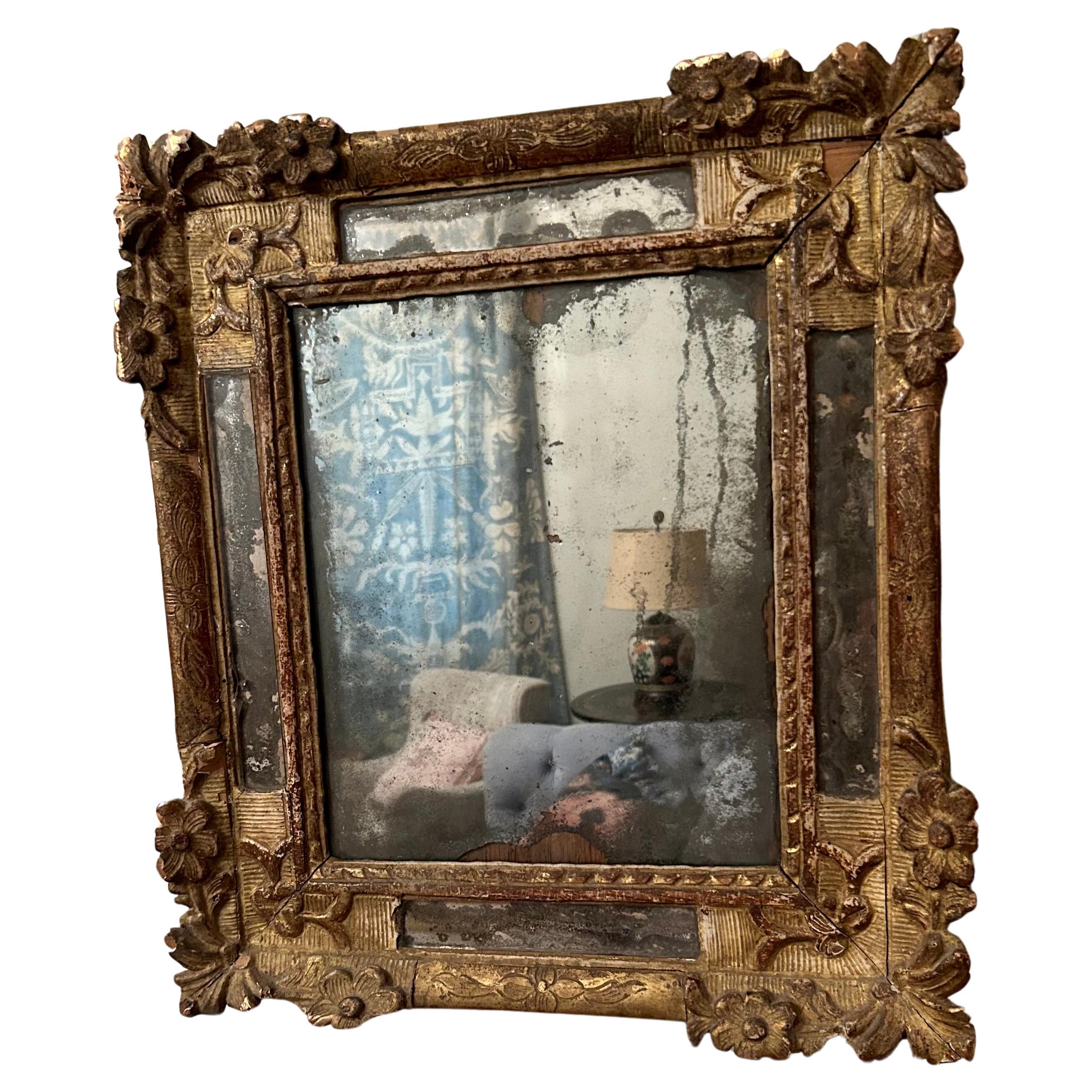 A rare and exquisite Régence small French parclose mirror, circa 1725. This piece has retained all of its mercury glass and has a beautiful patina. A true historical piece. 
Cracks and small losses throughout. Some edges of the frame have been