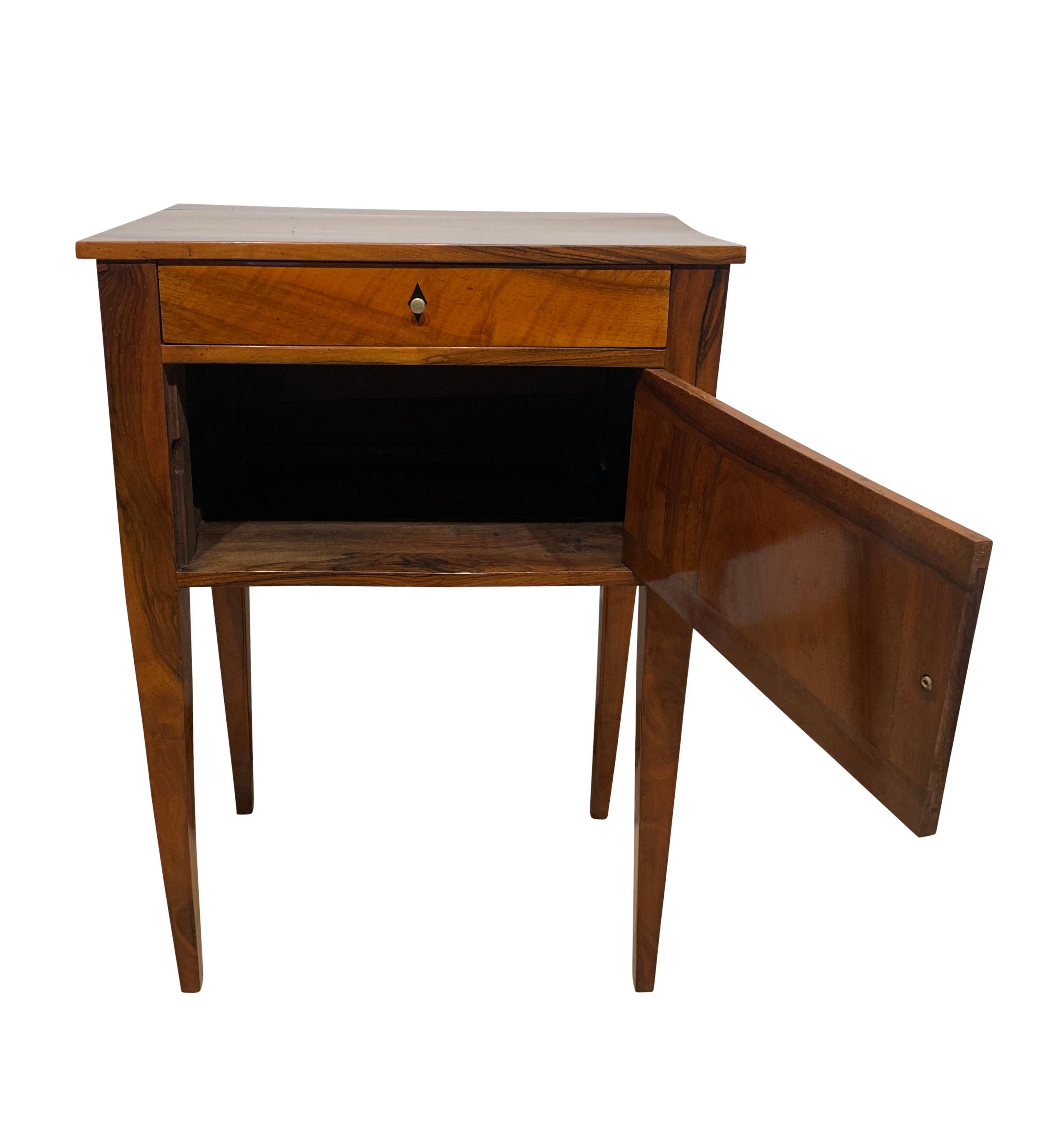Simple, antique small furniture / pillar cabinet / Side table from Biedermeier period / french Restauration around 1820.

Solid walnut, french polished with shellac hand rubbed.
One door and one drawer. Conical square tapered legs.
Brass knobs
