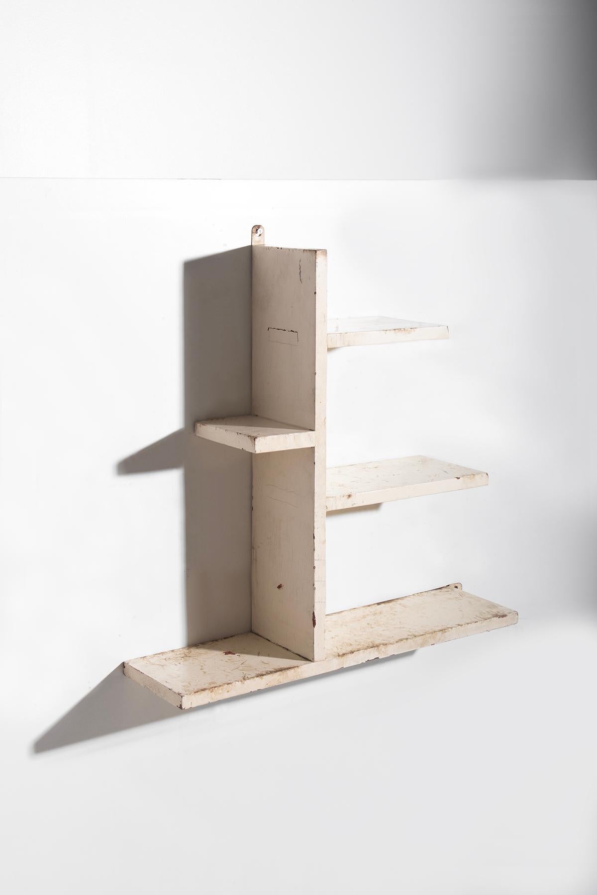 Dieses weiß lackierte Wandregal aus Holz mit seinen essentiellen und geometrischen Linien verkörpert perfekt den visionären und dynamischen Geist des italienischen Futurismus der 1910er und 1920er Jahre. Jeder Winkel und jedes Regal scheint die