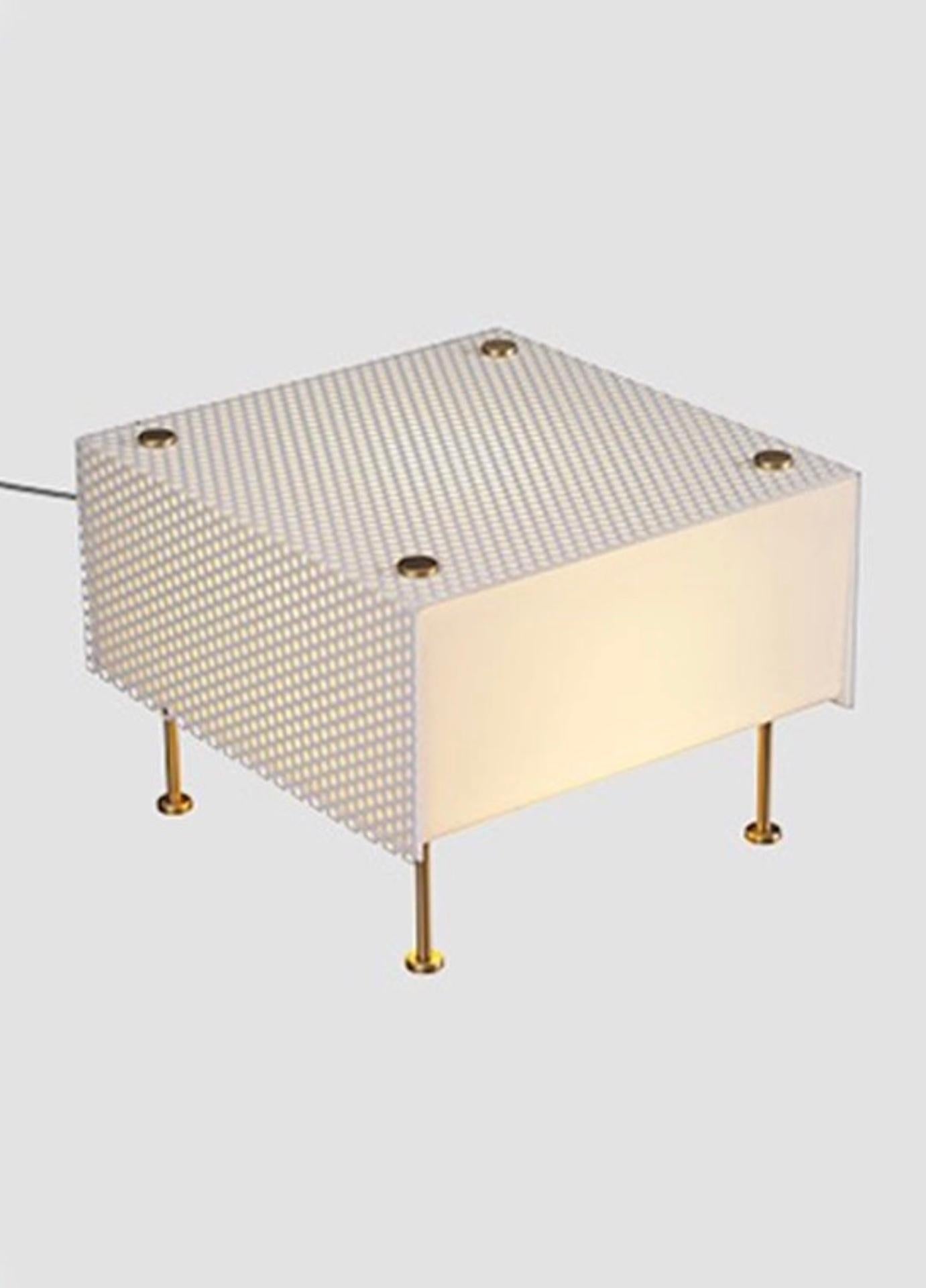 The G61 table lamp brings new life to a bookcase, coffee table or any place of relaxation. This cube of light with its white lacquered perforated sheet metal cover is available in two sizes: Small or Medium. Designed by Pierre Guariche in 1959,