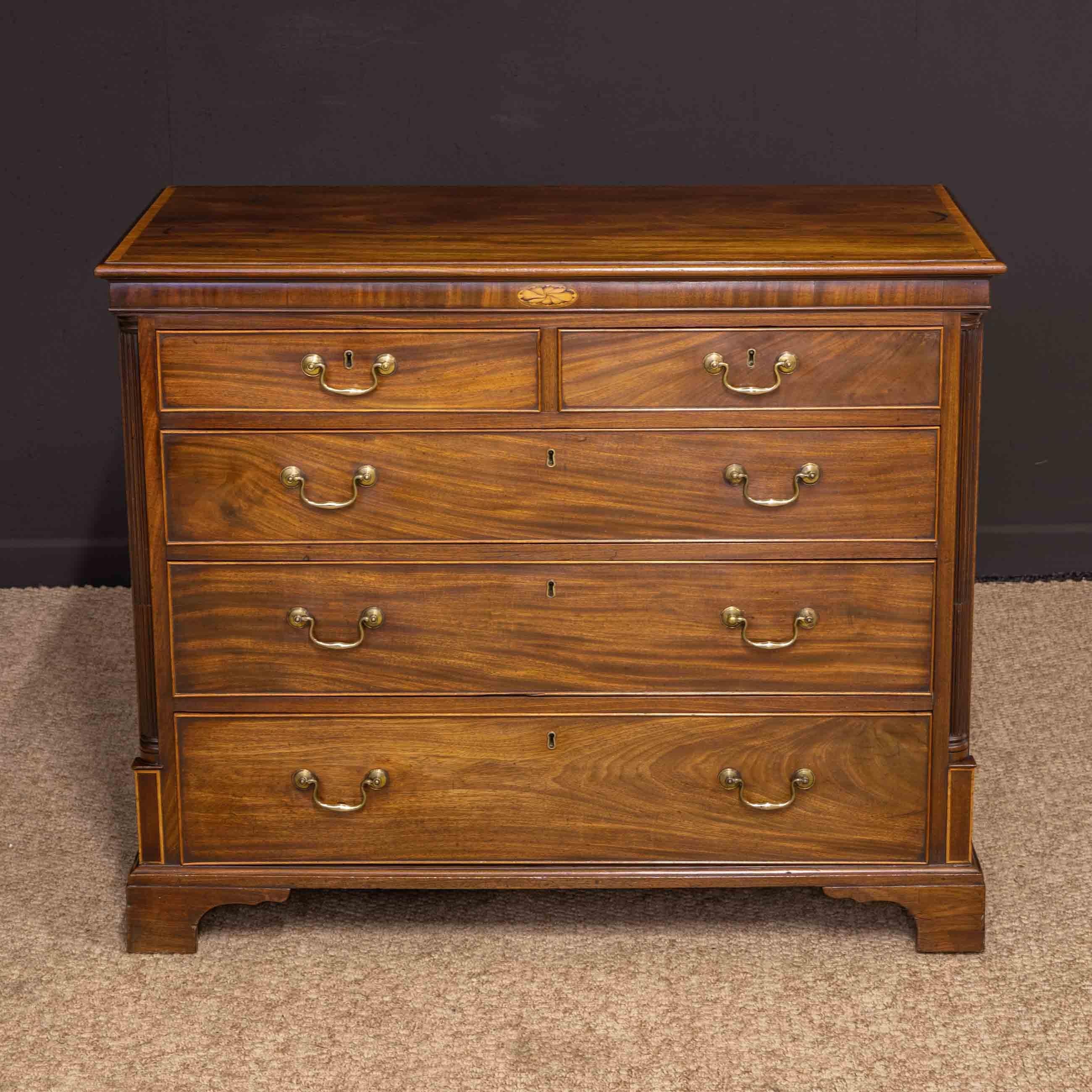A very attractive small Georgian mahogany chest with pine lined drawers and back. The top is crossbanded in fruitwood and gives way to an unusual frieze that has been made with a slight bow. The centre of the table has a delightful inlaid cartouche