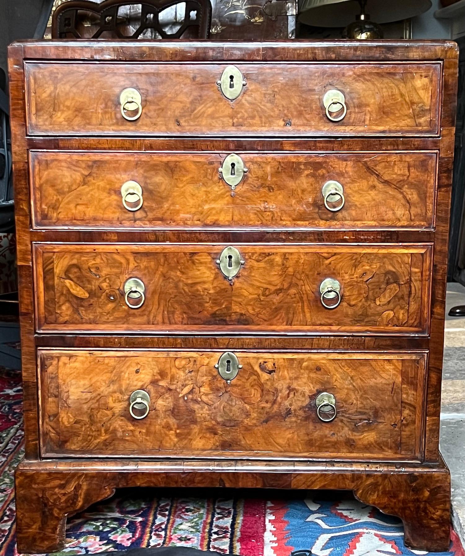 A George I period burr walnut chest of rare small proportions. Circa 1720.

This rare English early-18th century caddy-top chest retains good rich colour and patina.

Four graduated cockbeaded, oak-lined working drawers. Brasses original.
In