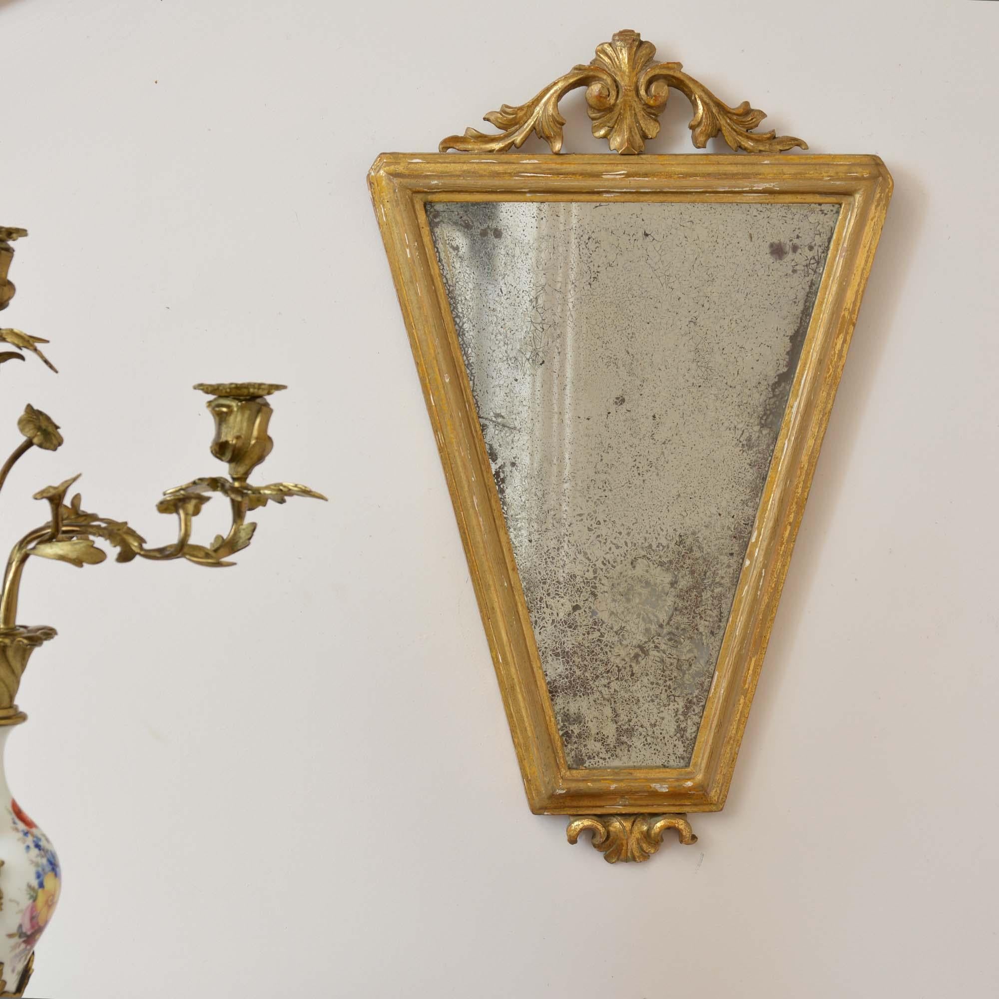 George II tapering giltwood mirror
Of elegant tapering form with a carved and rubbed water gilded frame, the lower foliate carving is missing its finial, the original mirror plate is wonderfully foxed. 
English, circa 1740.