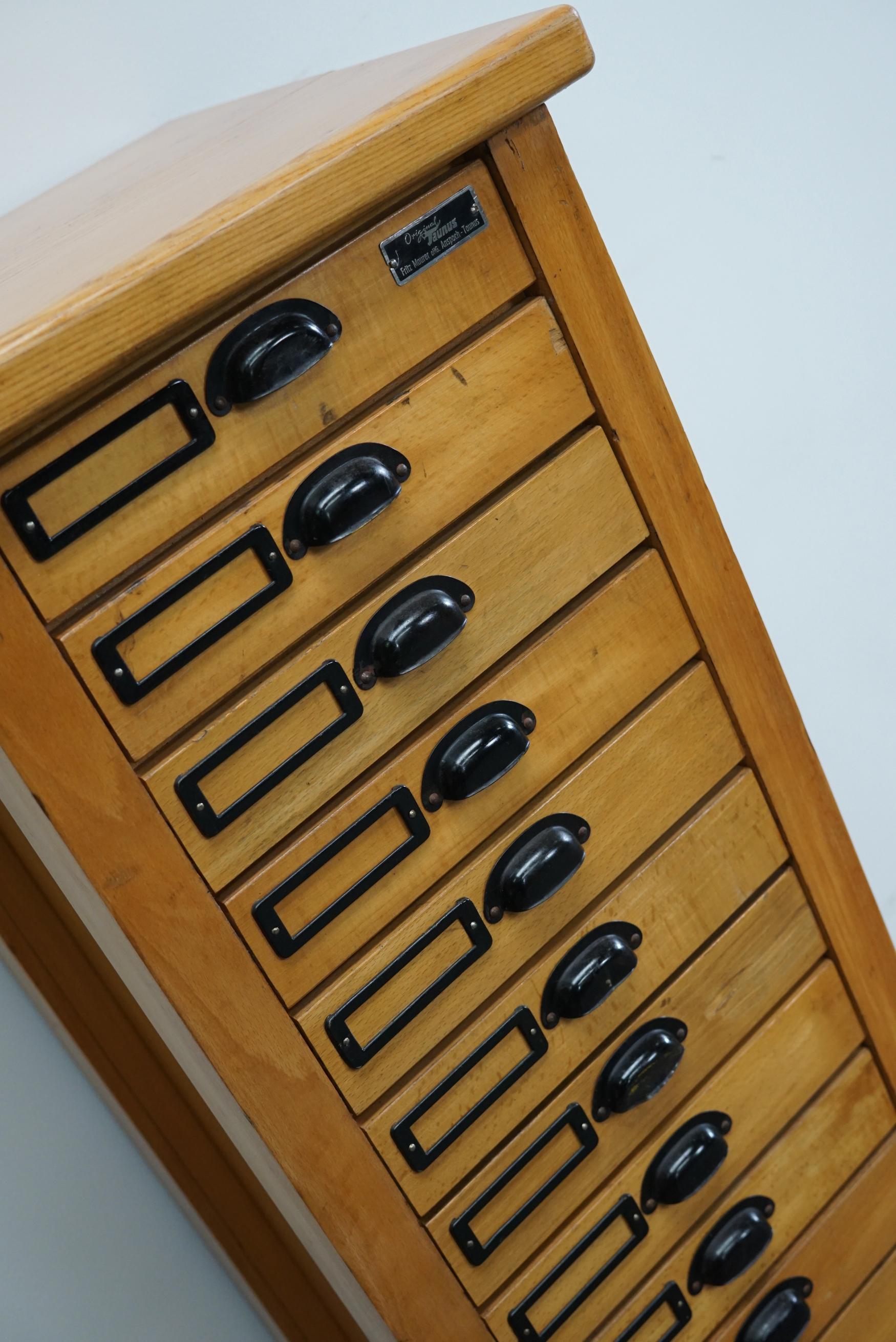 This apothecary cabinet was made circa 1950s in Germany. It features small drawers with nice hardware. It is made from beech and oak. The interior dimensions of the drawers are: D x W x H 29 x 23 x 4 cm.
   