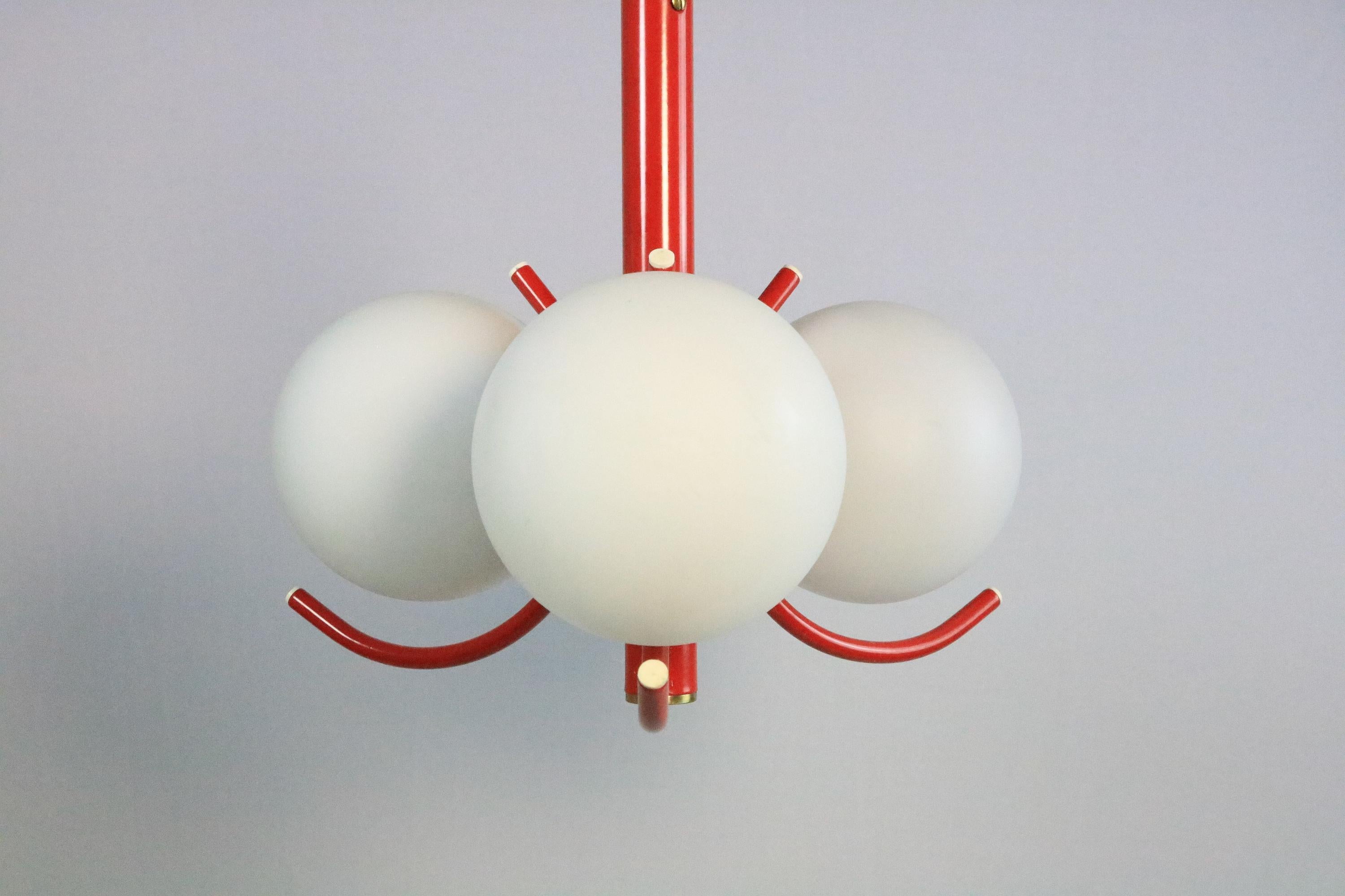 Small, attractive sputnik lamp with three opal glass globes. Red metal frame.
 
Manufacturer: Richard Essig
 
Height: 65 cm / 25.6 inches
Diameter: approx. 35 cm / 13.78 inches

Very good condition.
 
A matching white sputnik chandelier can be found