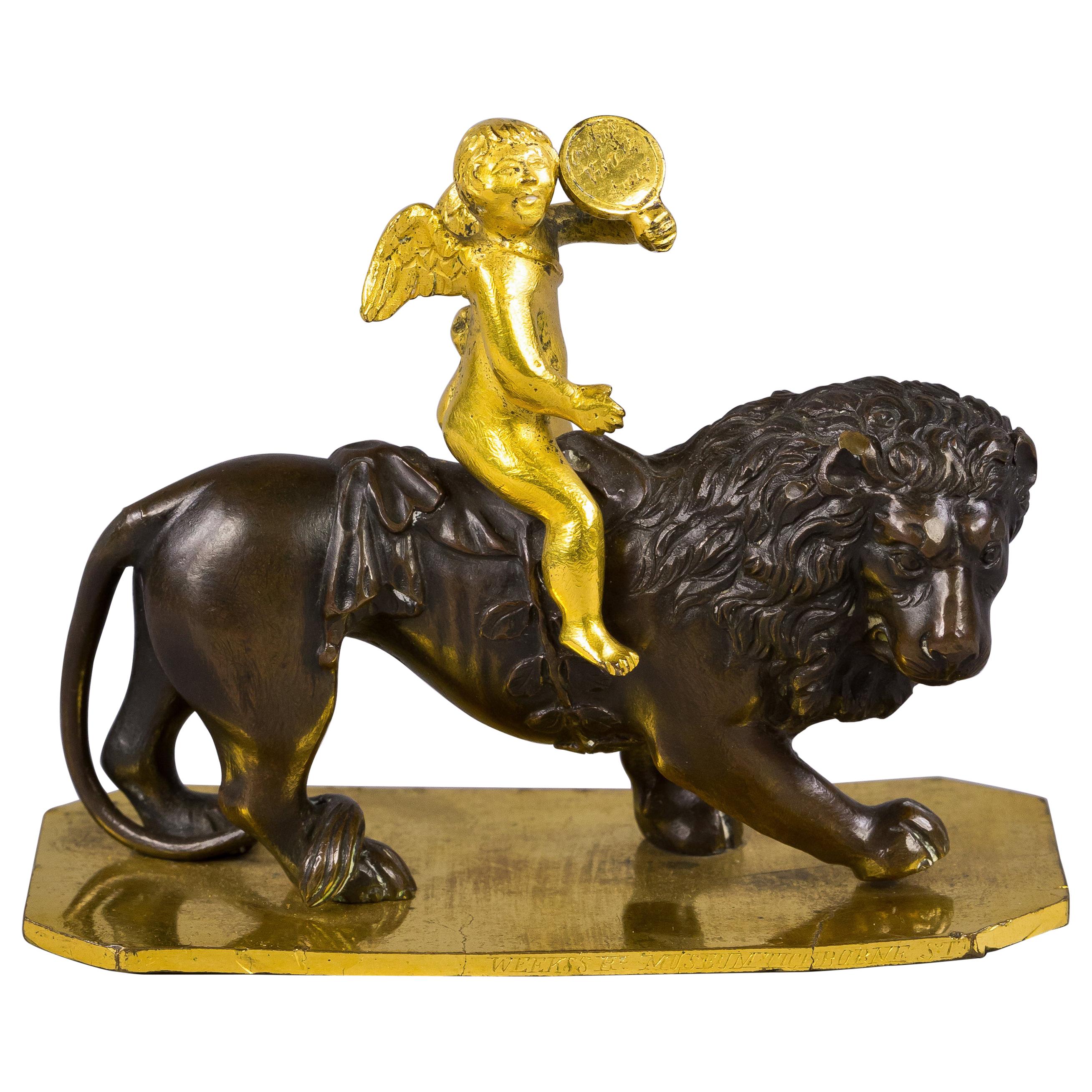 Kleine vergoldete und patinierte Bronze von Amor auf einem Löwen:: um 1820