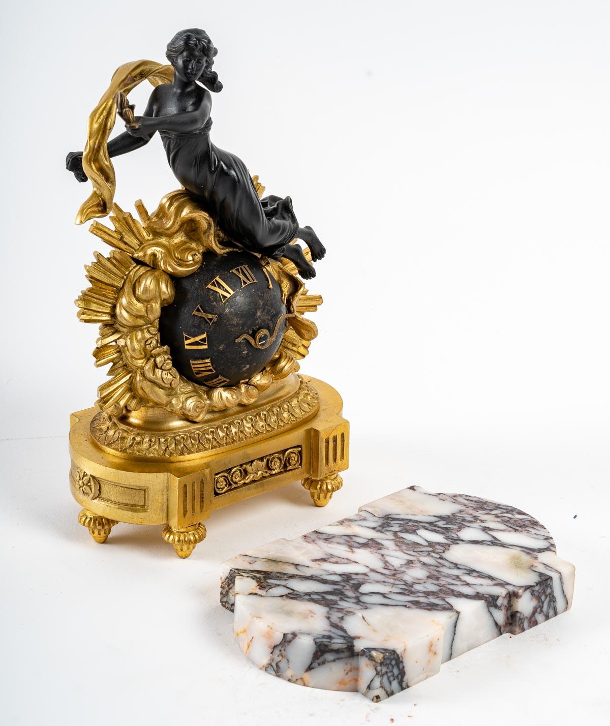 A small gilt bronze and patinated bronze clock, 19th century, Napoleon III period, Louis XIV style on a marble base.
Measures: H: 25 cm, W: 16 cm, D: 10 cm.
 