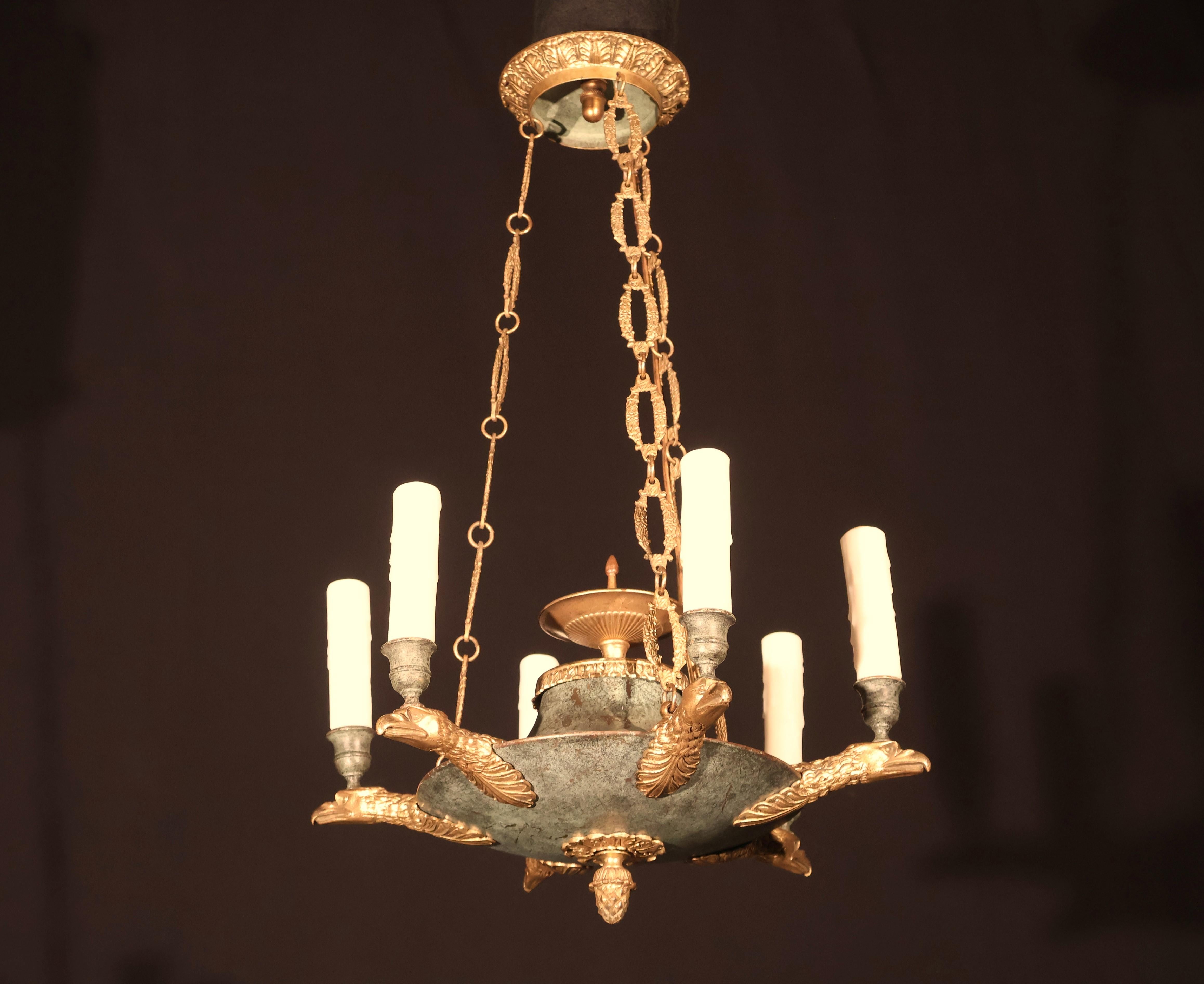 Ein sehr feiner und dekorativer Kronleuchter aus vergoldeter Bronze und patinierter Bronze im Empire-Stil. 6 Lichter. Frankreich, um 1920. 
Abmessungen: Höhe 25