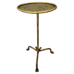 Petite table à boissons en fer doré sur une base tripode incurvée 