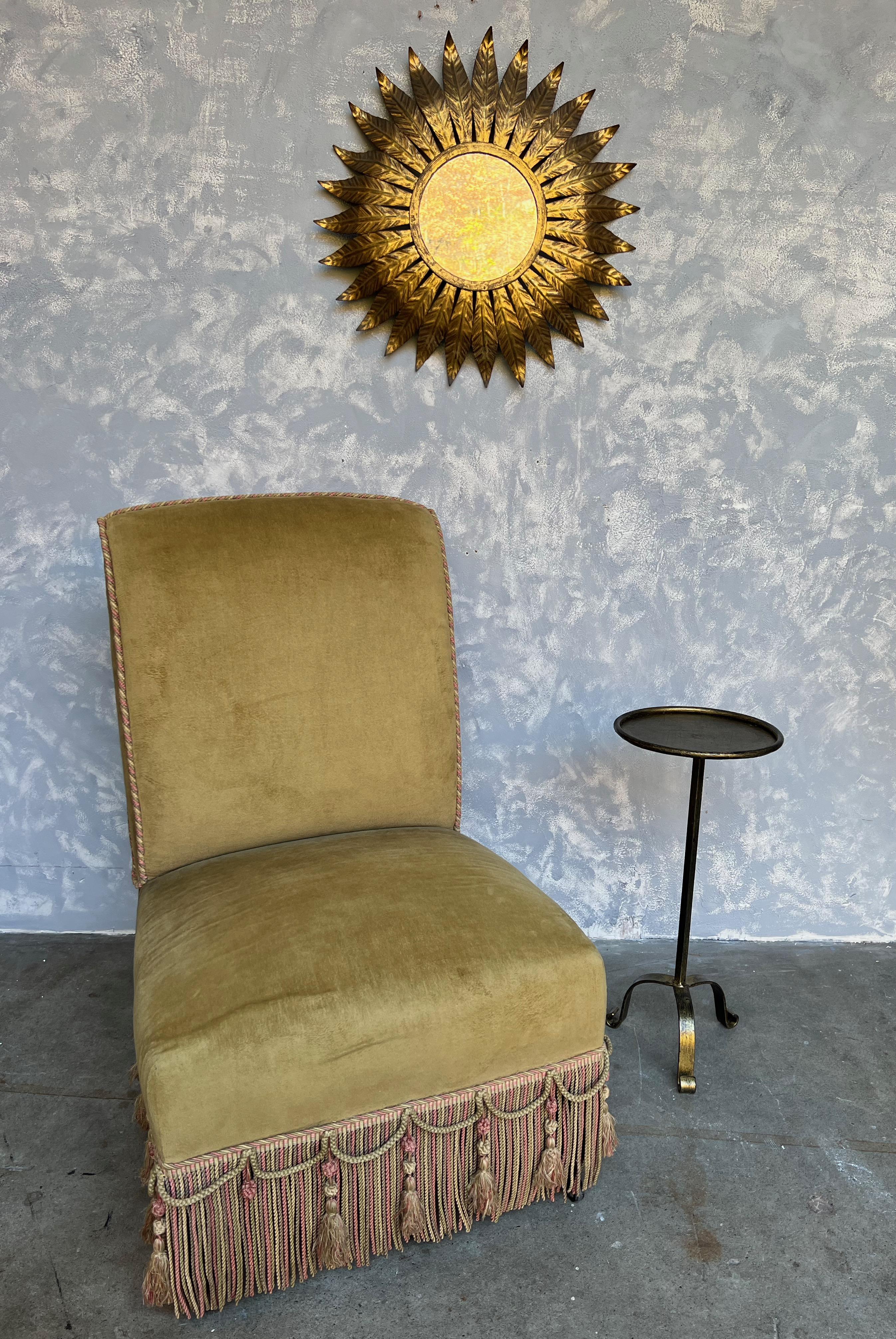 This small metal and iron side table is a true gem of Spanish craftsmanship from the 1950s. The table features a hand applied gilt finish on both the 9½ inch diameter top and the tripod base, which adds a touch of elegance and luxury to the piece.