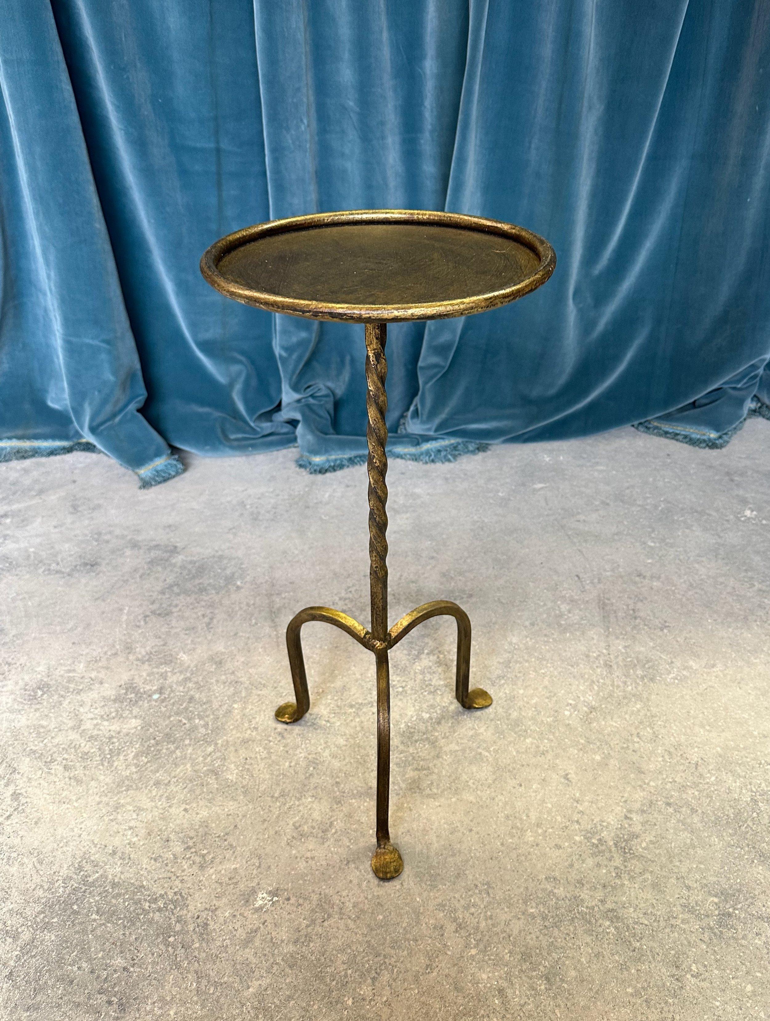 A handsome Spanish gilt iron drinks table, recently crafted to our design and specifications, is a unique and charming piece that will surely catch the eye. This small side table features a twisted stem design mounted on a sturdy tripod base,