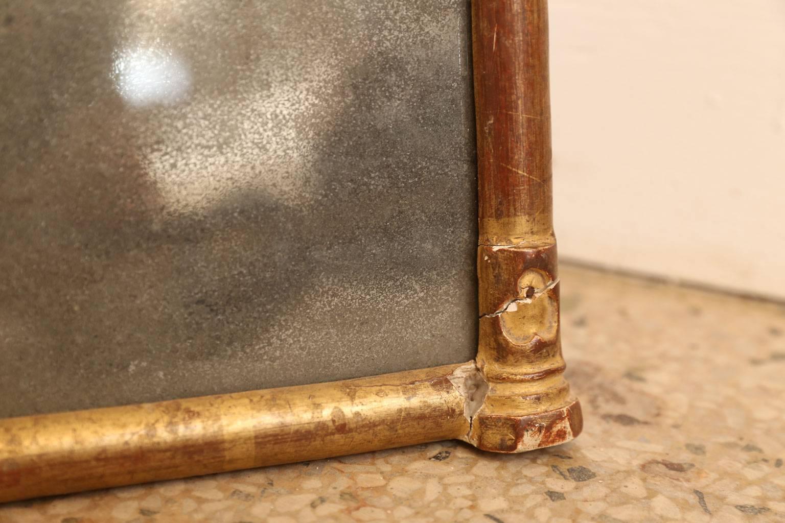 Small giltwood mirror in neo-gothic style from France. This diminutive 19th century mirror consists of a gilded hand carved wooden frame with its original mercury mirror. Perfectly suited to display on a shelf or tabletop.