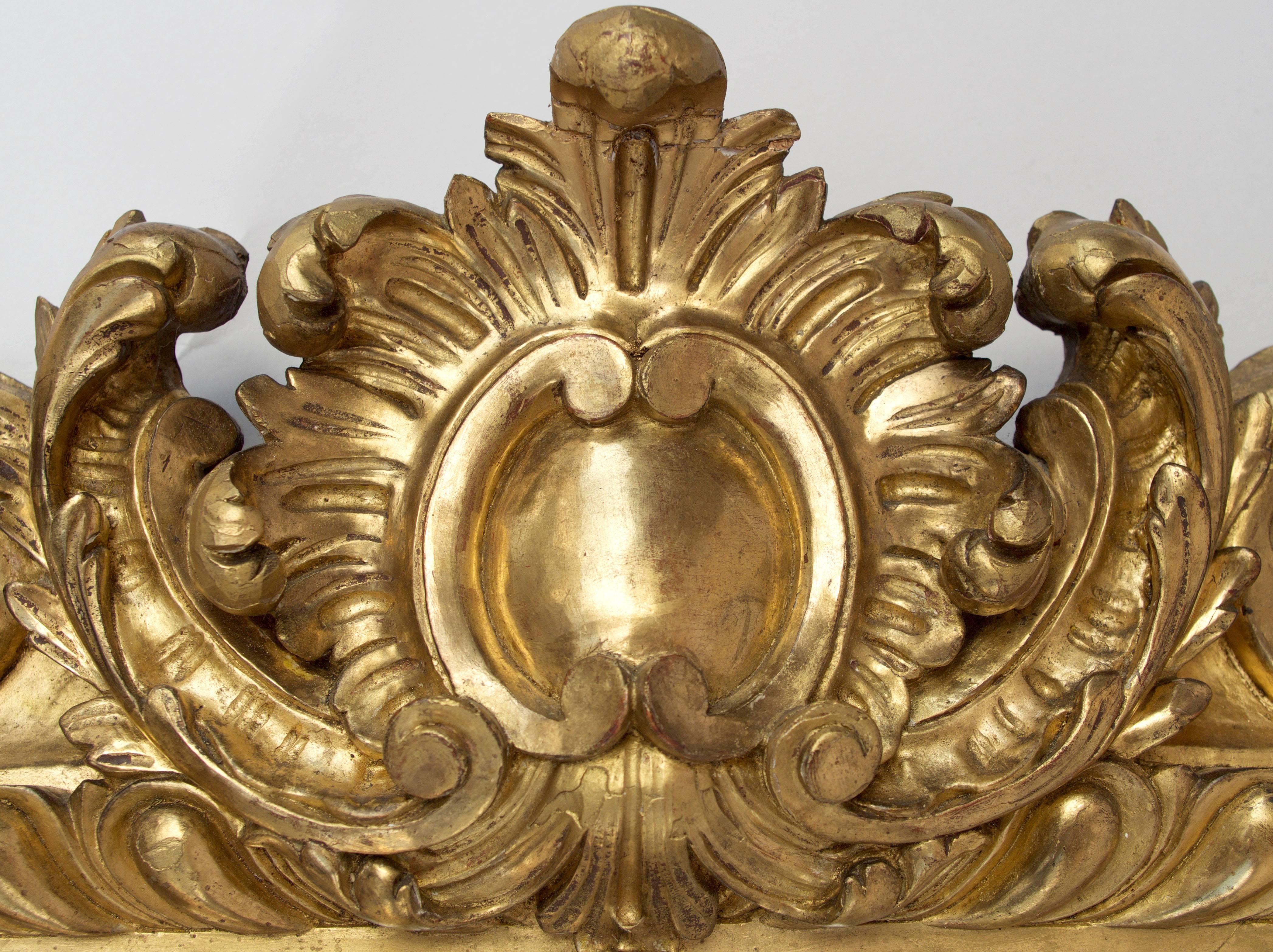 Rectangular small Regence style mirror in carved and giltwood.
Frame adorned with a thick gadroon frieze and embellished with shells, plans and flowers scrolled. 
A Cartouche in the Meissonnier style ornaments decorated the upper central part of