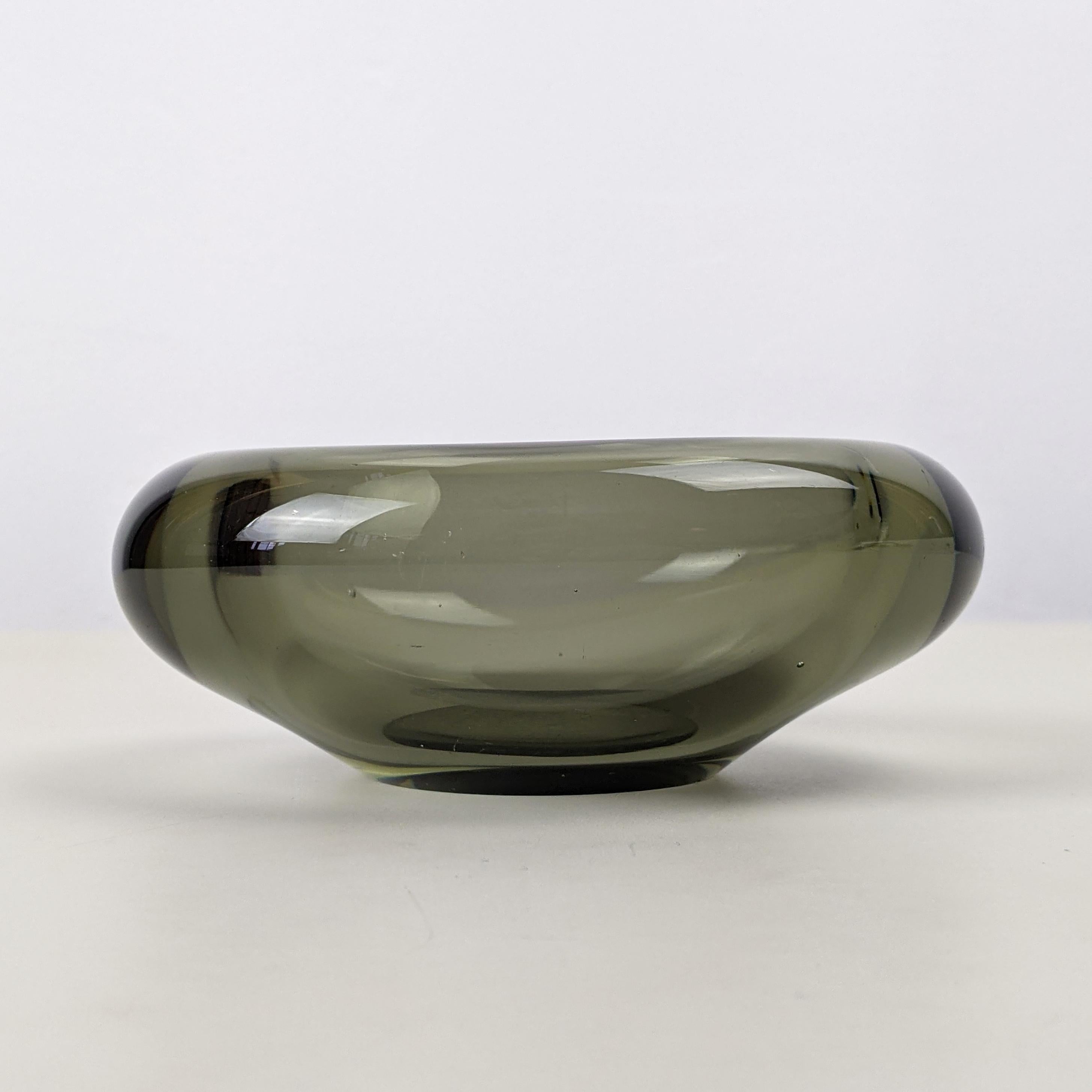 Per Lütken for Holmegaard
Small glass bowl, designed 1957, this example from 1961

Clear grey-tinted blown glass
Underside engraved 'PL 1961 Holmegaard'
Good condition with a few minor scratches

Dimensions, approx..:
Length 12cm, width 9cm,