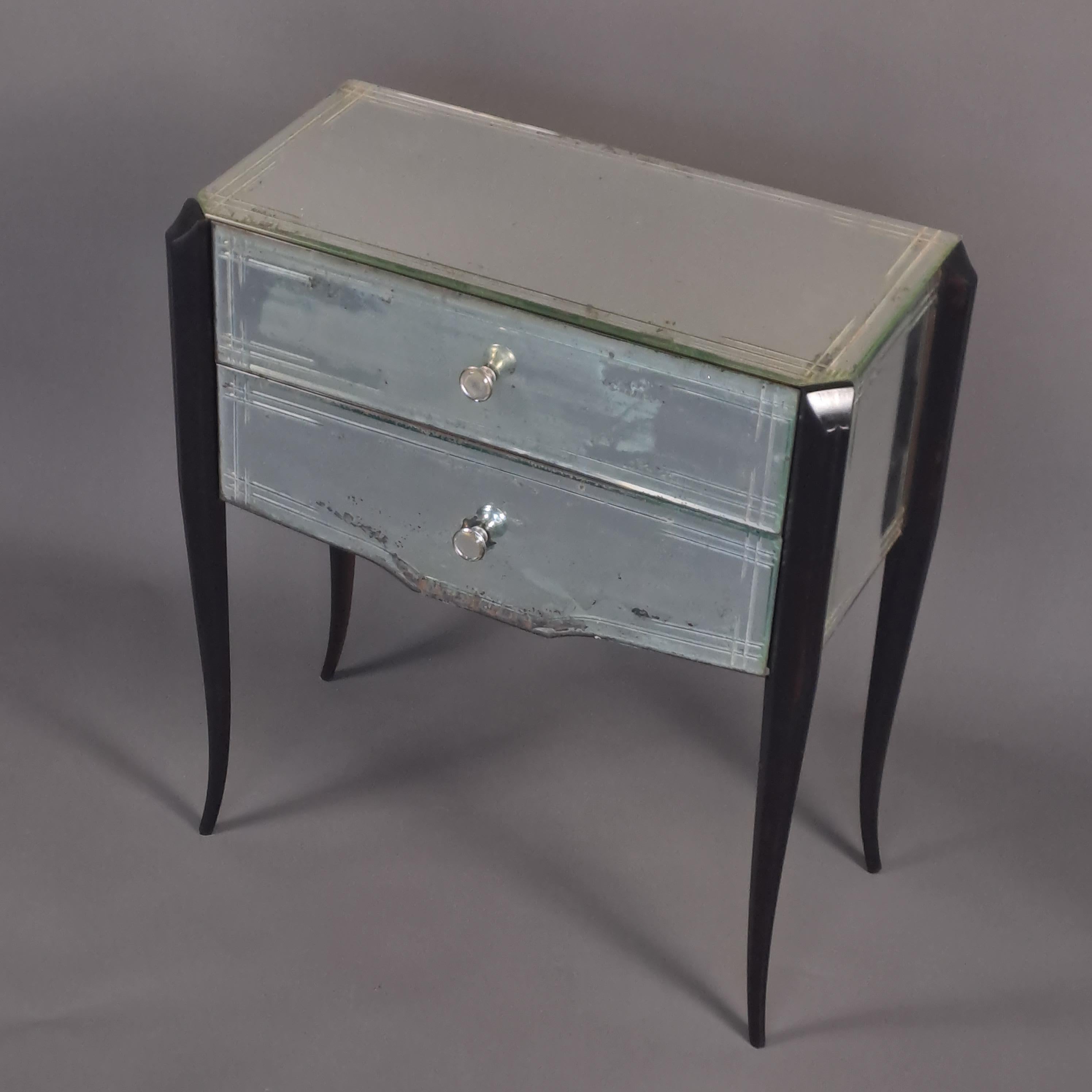 Amusing little in-between chest of drawers in bevelled and chiseled glass, opening two drawers without crosspieces and resting on four elegantly arched stained wooden legs.

French work of good qualité from the 1950s: traditional assembly, dovetail