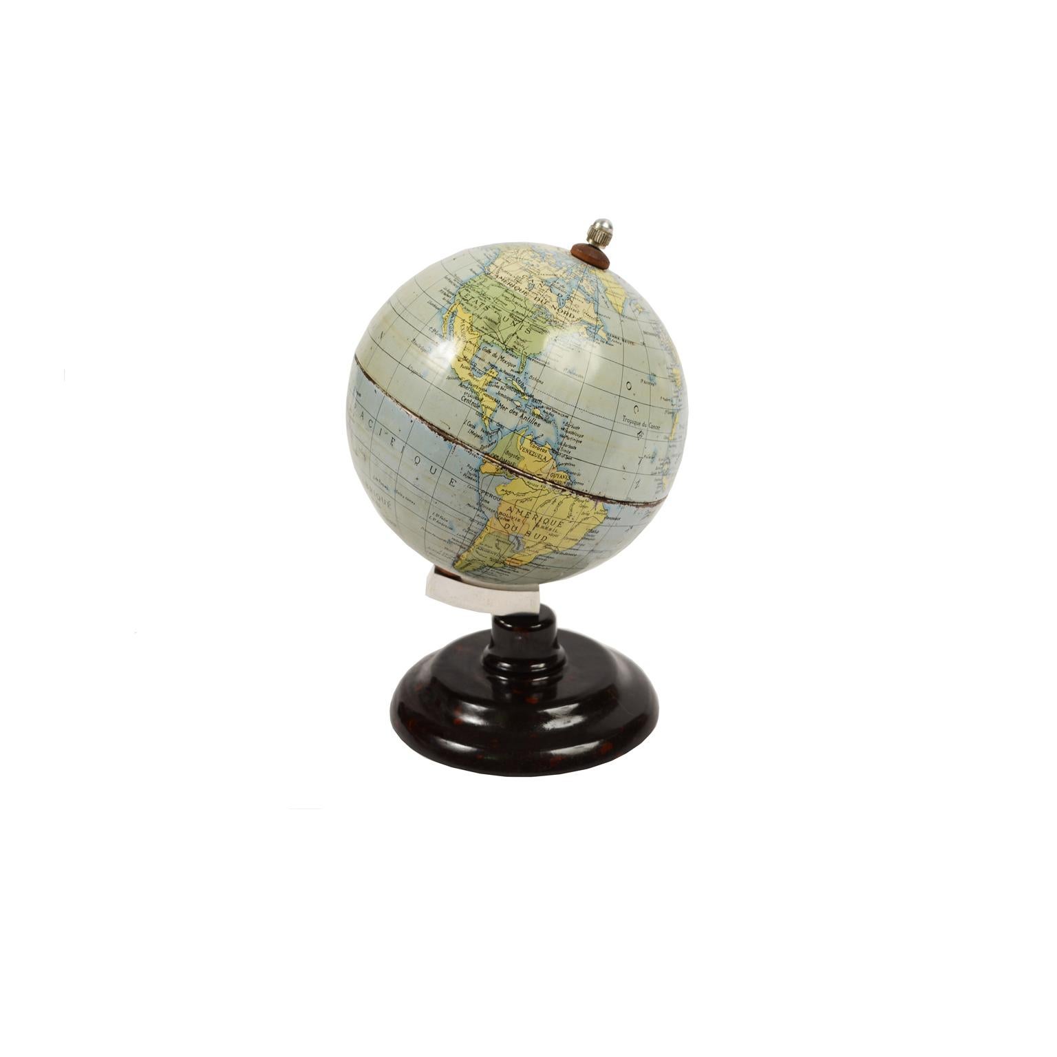 Small terrestrial globe made of lithographed tin and ebonite base made in England for the French market in the early 1950s. Very good condition. Measures: Height 18 cm - 4.33 inches, sphere diameter 11 cm - 7 inches.
  