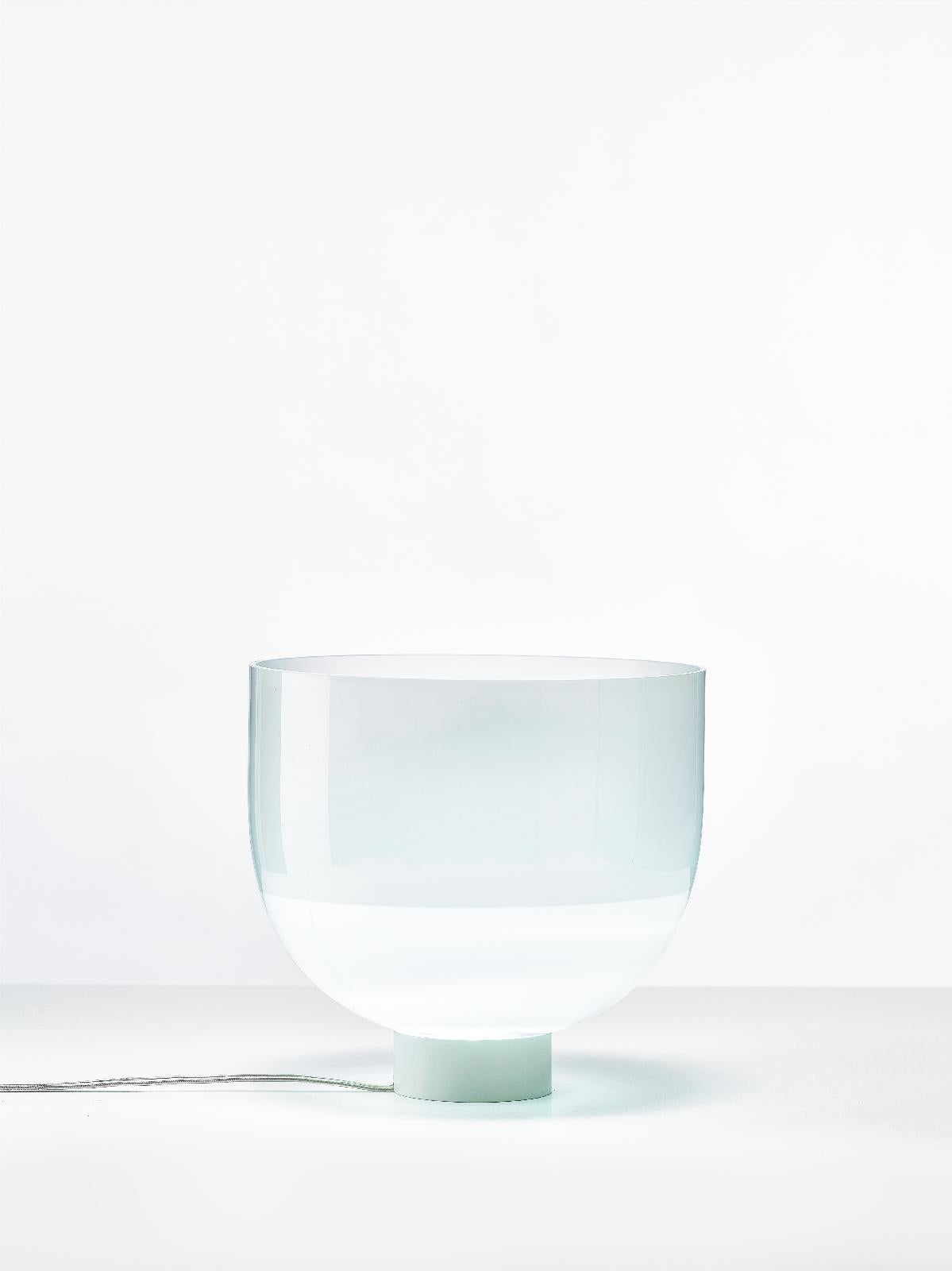 Small glowing vase table lamp by Dechem Studio.
Dimensions: D 25.5 x H 23.5 cm.
Materials: glass.
Available in 2 sizes: H 23.5, H 38.5 cm.

Something between vase and lamp, Glowing Vase is a hybrid interior object, produced in clear cloudy