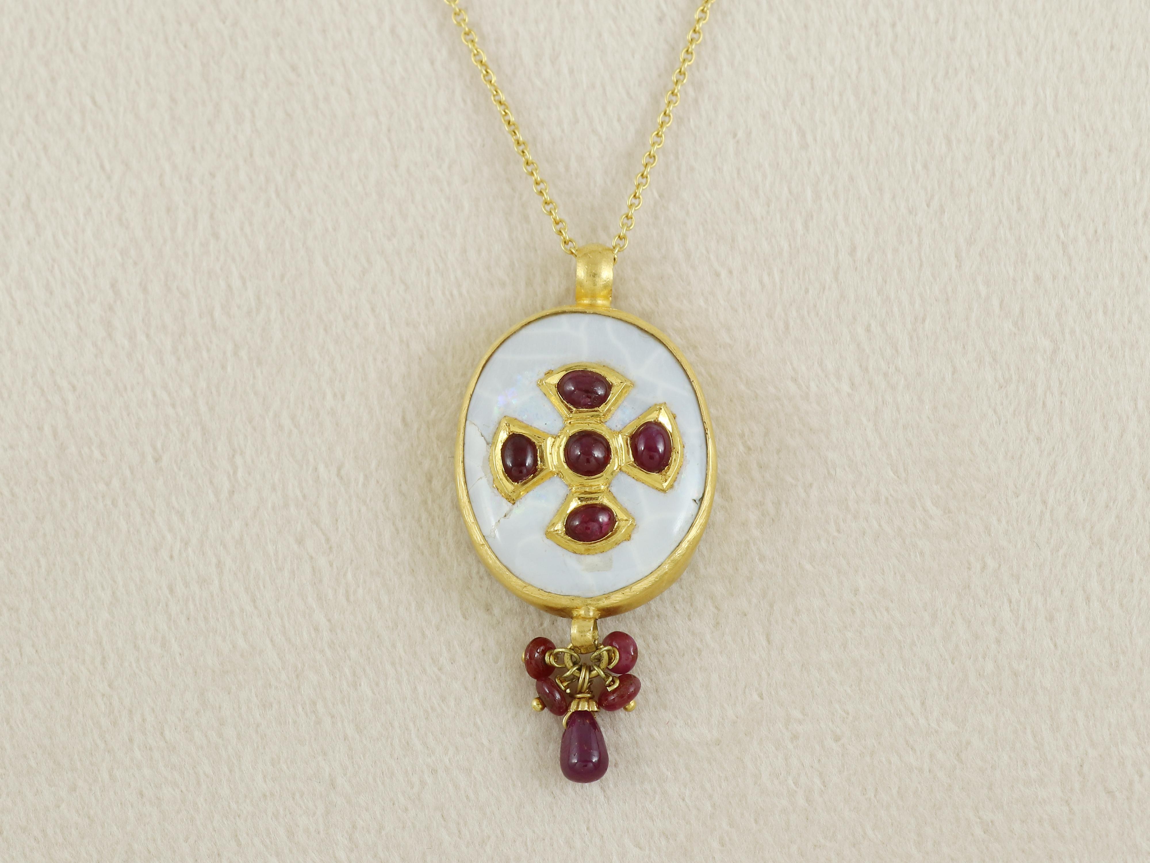 A small antique indian pendant which has been inlaid with natural rubies on a natural opal gemstone which is framed in 22K gold and has been suspended with fringe of natural rubies.

The pendant comes with a string of 14K gold.