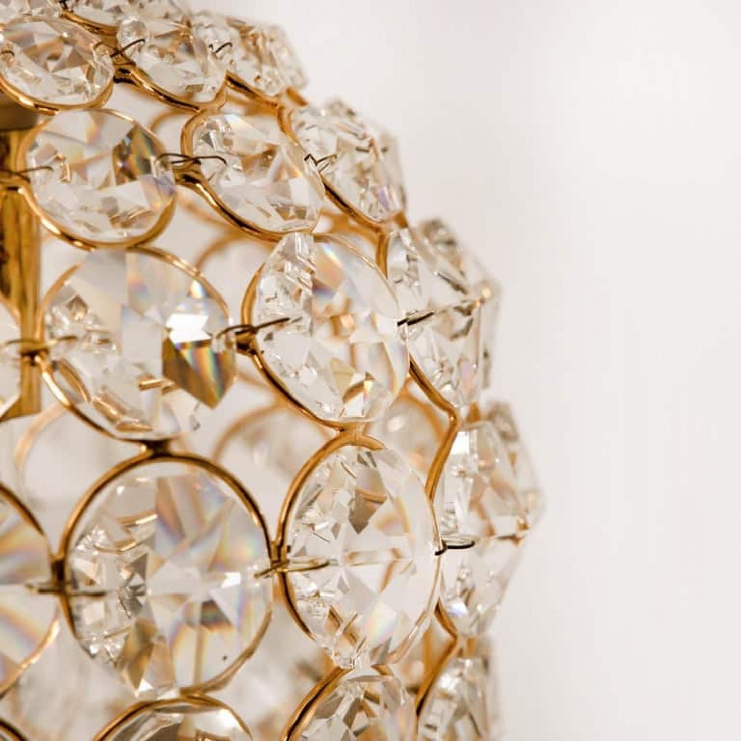 Questa bellissima e lussuosa lampada a sospensione presenta una pesante struttura in ottone e grandi pietre di cristallo. La struttura della lampada, la catena e il baldacchino sono in ottone. È stato prodotto in Germania negli anni '60 da Palwa.
