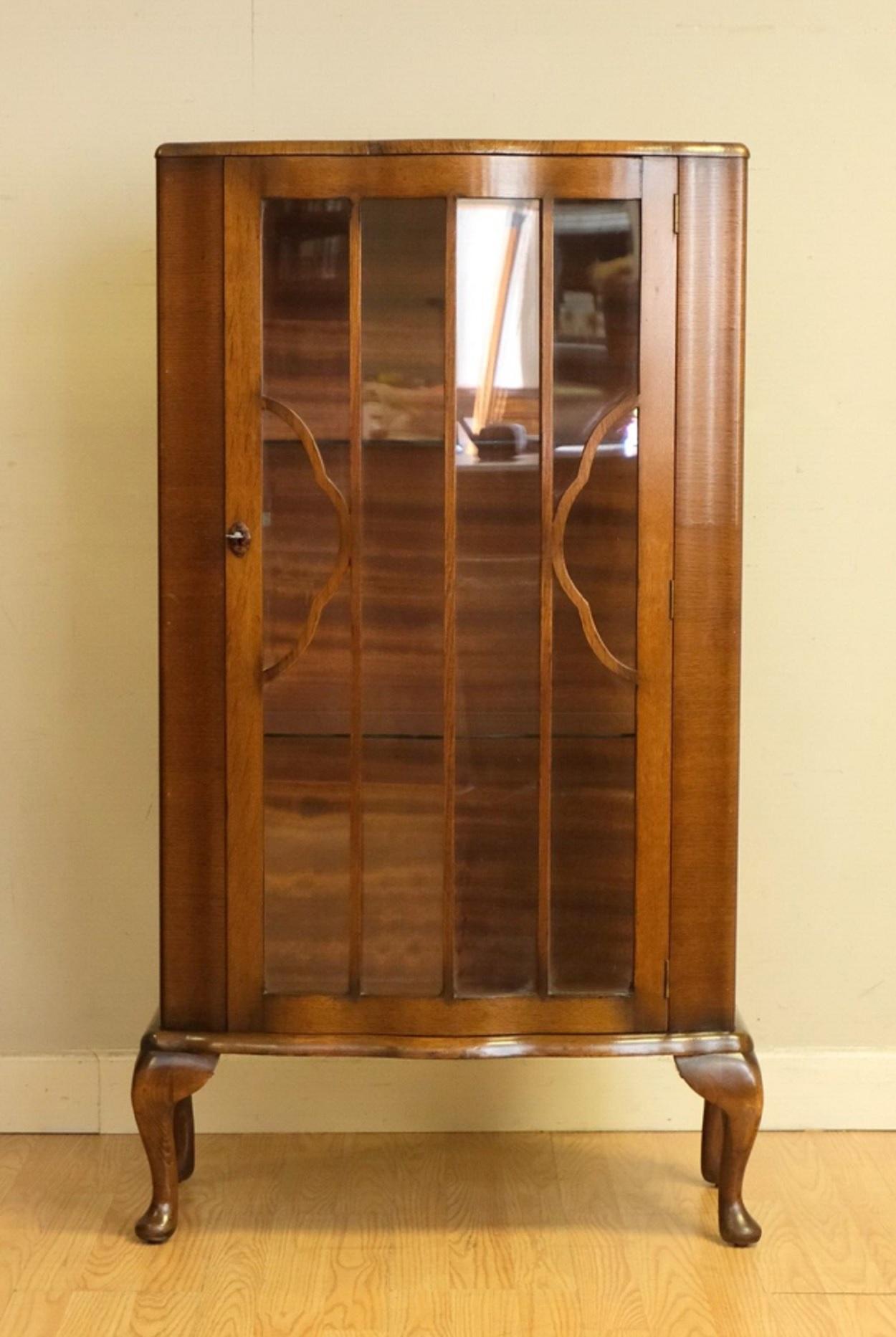 We are delighted to offer for sale this gorgeous display cabinet with a glassed front door and a pair of glass shelves.

This small and pretty display cabinet is presented with serpentine front, Queen Ann style legs and a pair of glass shelves. The