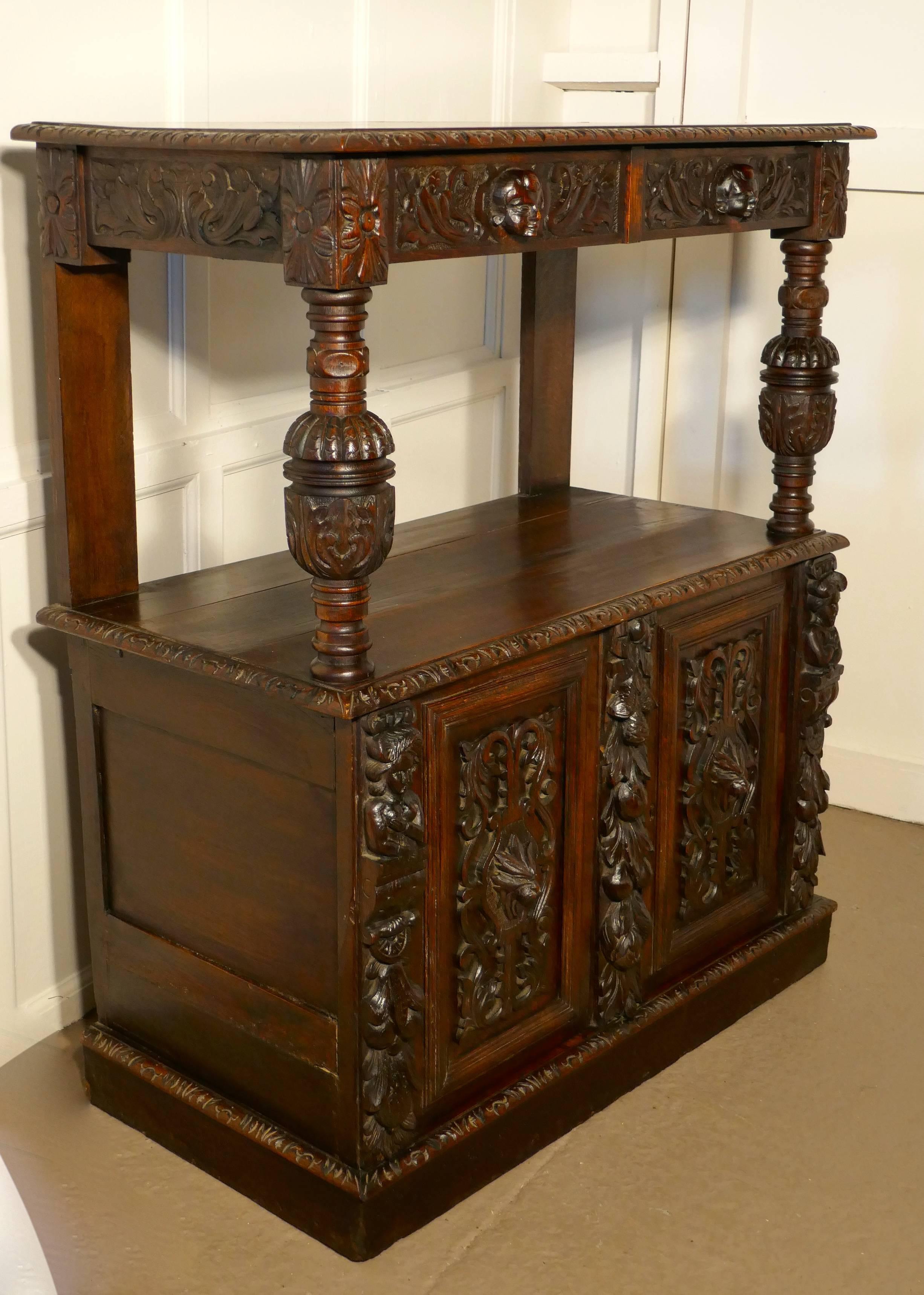 Small Gothic carved oak green man buffet with cupboard. 

This is a very fine and beautifully carved example of furniture in the Gothic style or Green Man Oak.
The buffet has a shelved cupboard at the bottom enclosed by two doors and a high top