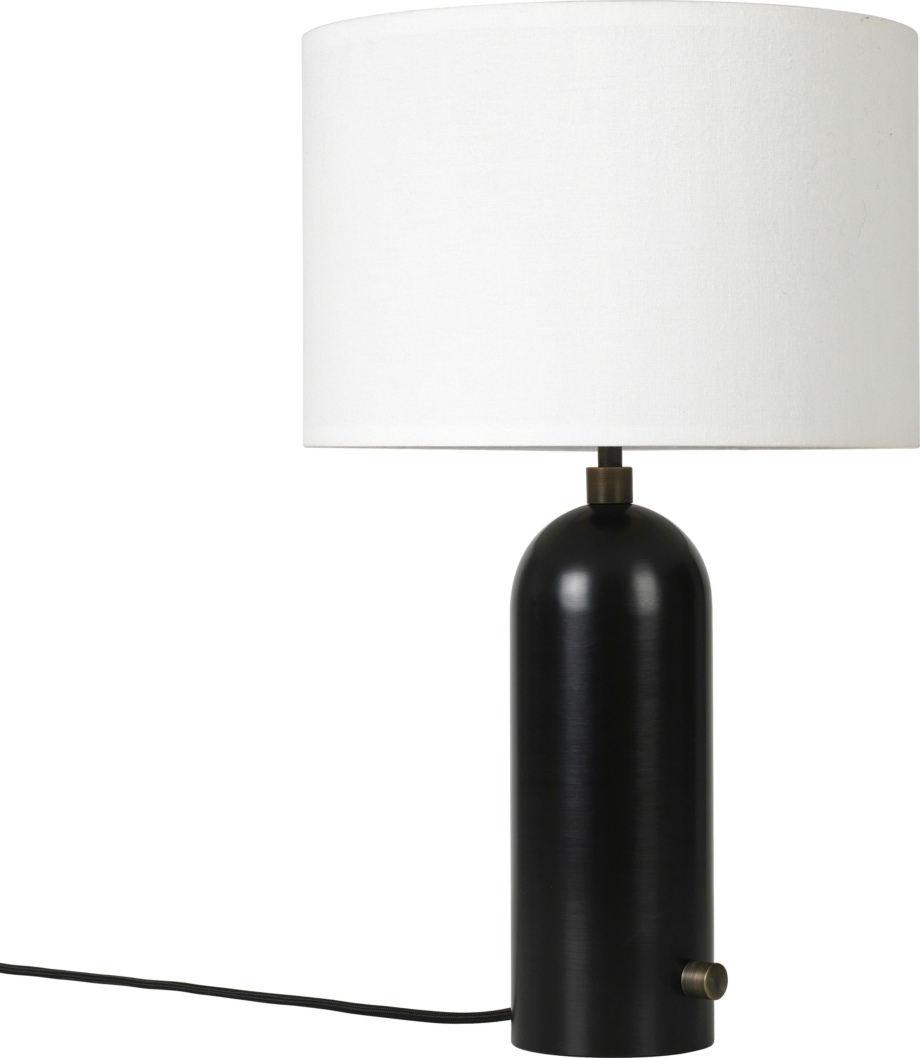 Small 'Gravity' Blackened steel table lamp by Space Copenhagen for Gubi.

Executed in blackened steel with a canvas or white textile shade perched atop its stem, the Gravity table lamp designed by Space Copenhagen for GUBI contrasts strength and