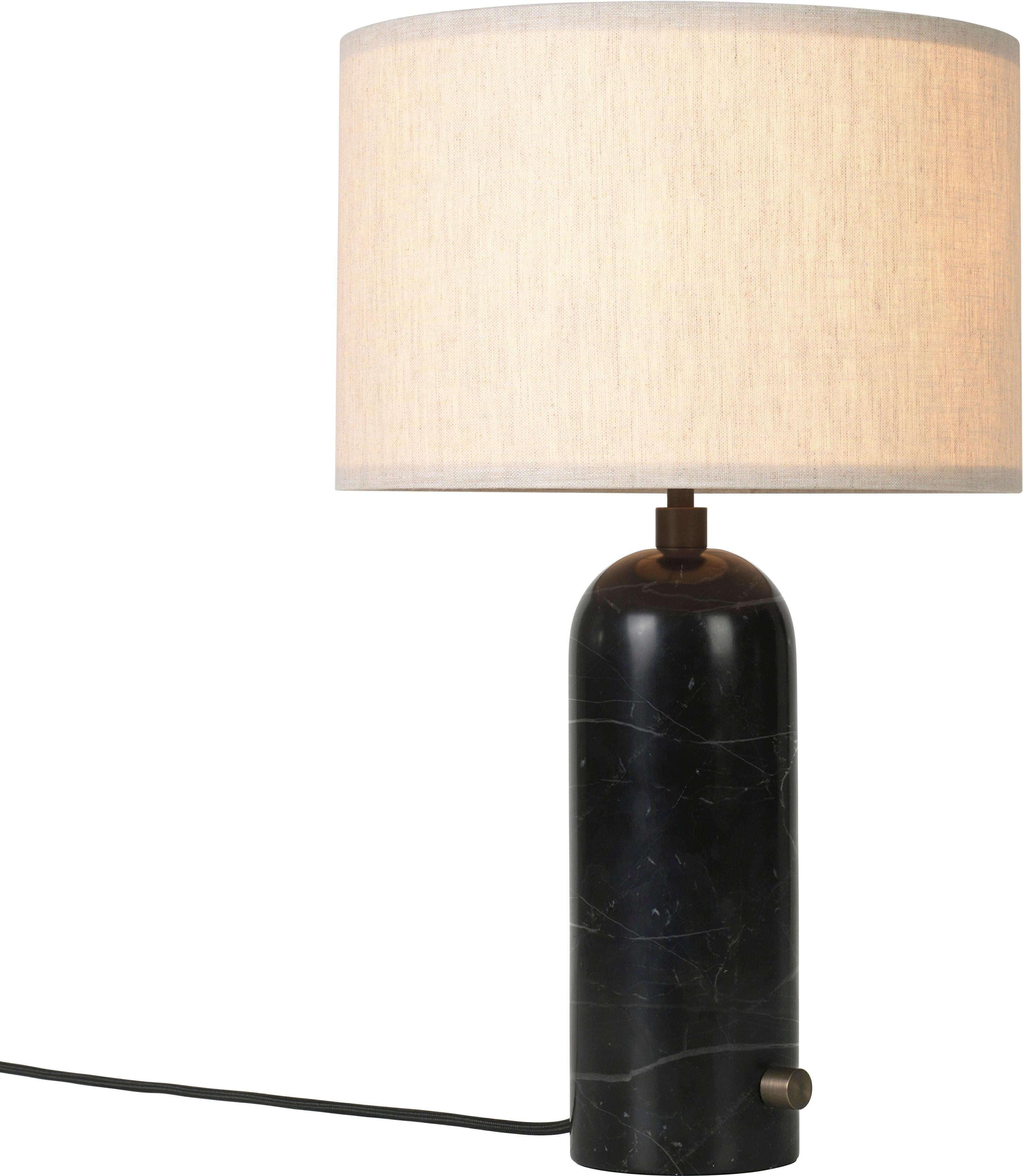 Small 'Gravity' marble table lamp by Space Copenhagen for Gubi in Black.

Executed in solid marble with a canvas or white textile shade perched atop its stem, the Gravity table lamp designed by Space Copenhagen for GUBI contrasts strength and