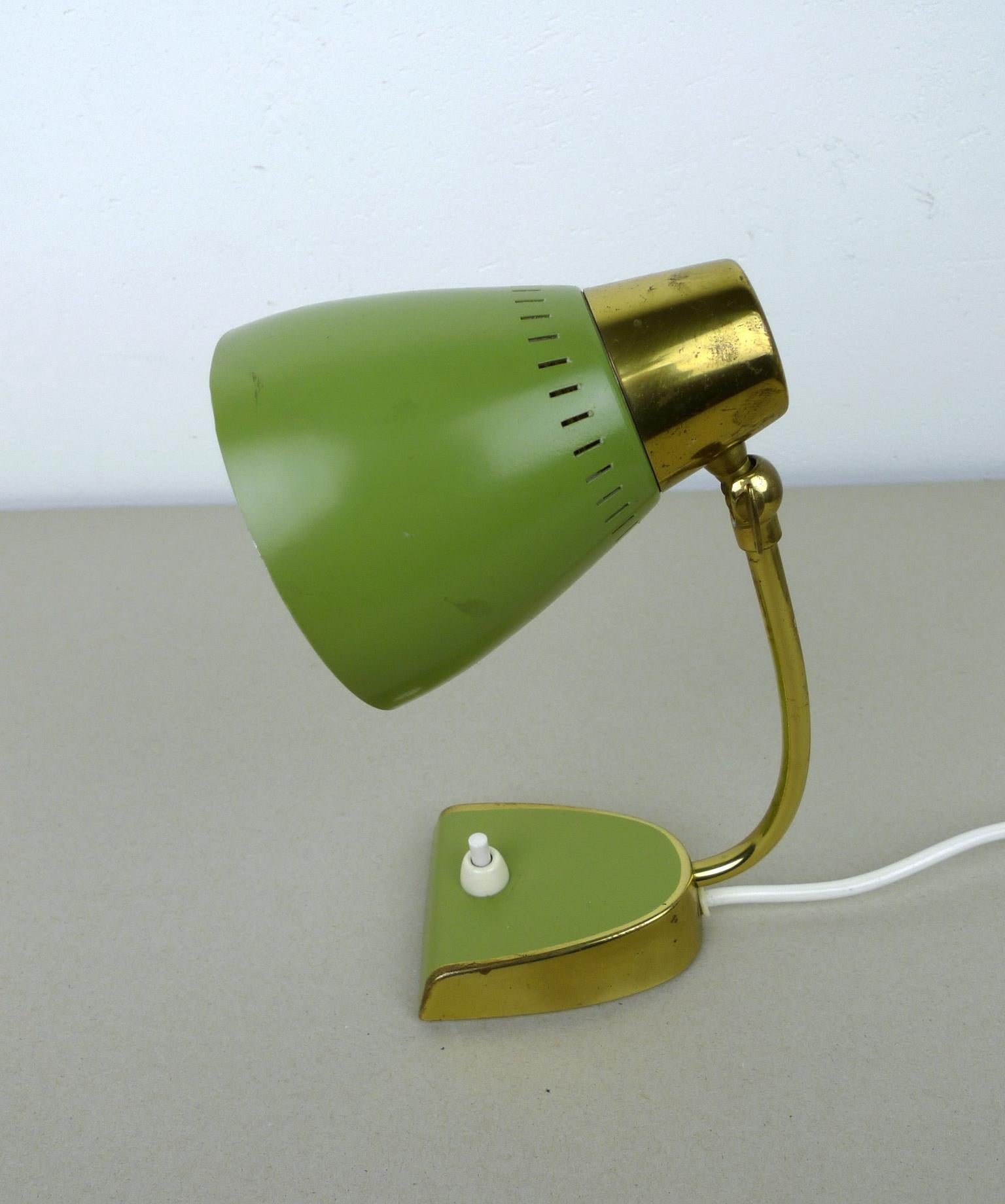 Small green bedside lamp from the 1950s with brass elements and a pressure switch on the Stand. It features an E 14 lamp socket and it is in good vintage condition.