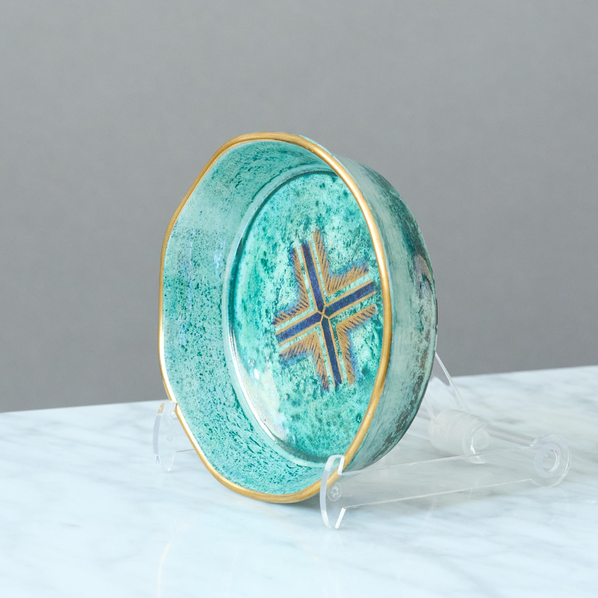 Una piccola e bellissima ciotola con un'incredibile smaltatura a lustro e dettagli dorati dipinti a mano. Grazia scandinava / Art Deco.
Realizzato da Josef Ekberg a Gustavsberg, Svezia, nel 1929.

Ottime condizioni. Alcuni scolorimenti nella parte