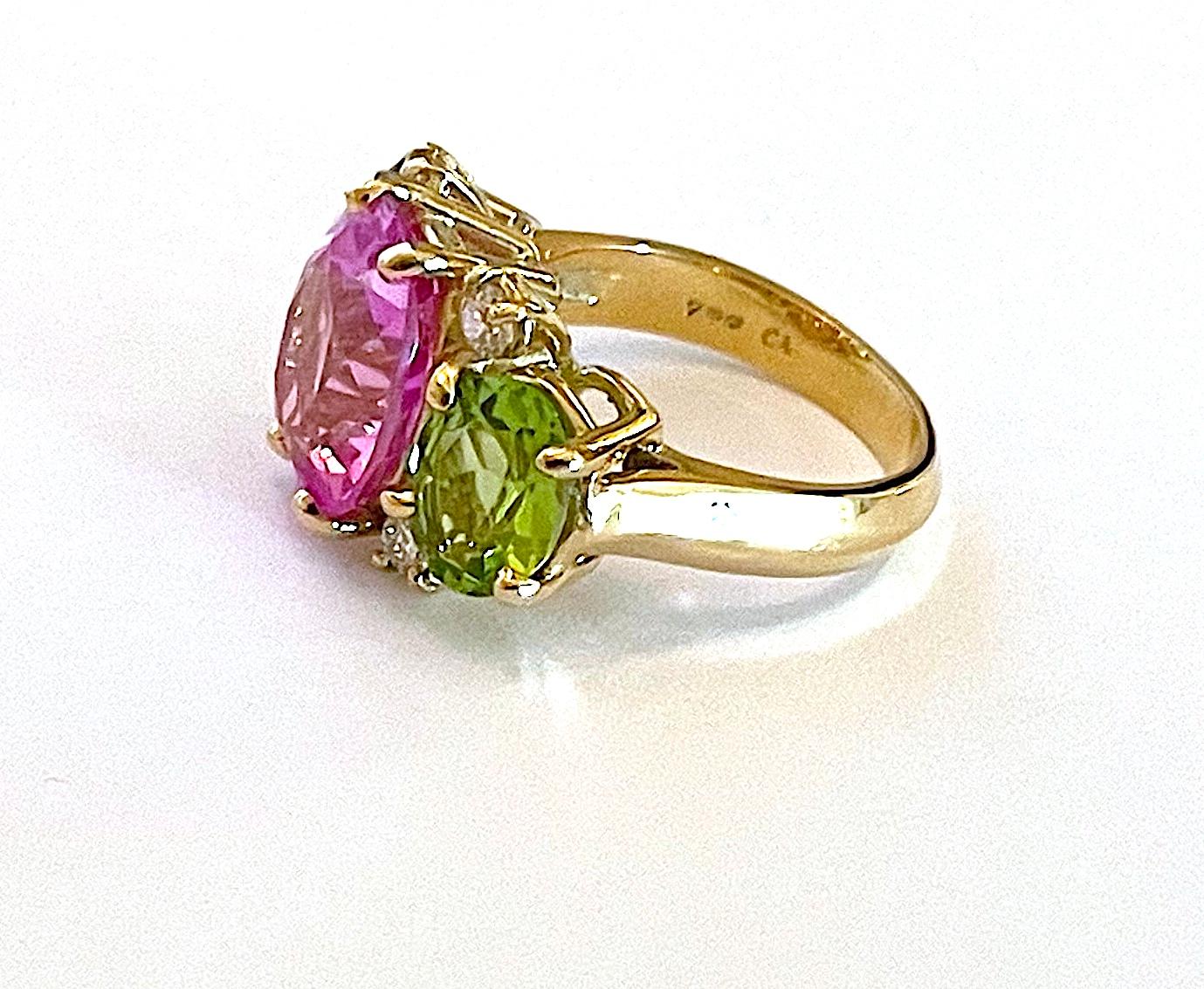 18kt Yellow Gold Small GUM DROP™ Ring with Pink Topaz (approx 4cts) and two Peridot (approx 5 cts) and Diamonds approximately~ 0.30cts

This beautiful ring measures ~ 1 1/2 