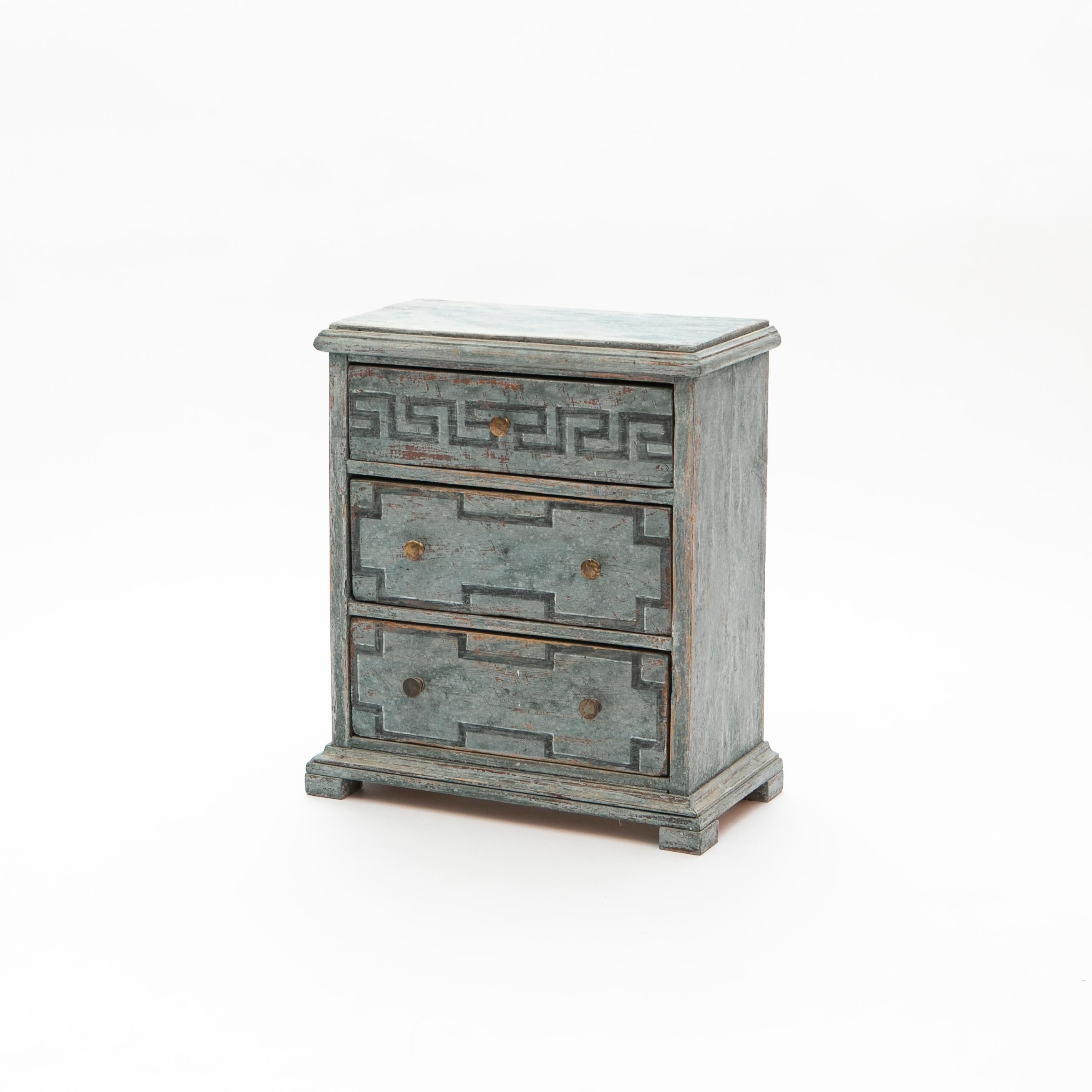 Kleine schwedische Kommode oder Nachttisch aus blau lackiertem Holz. Höhe: 47 cm / 18,5 inch.
Diese kleine Kommode aus dem frühen 19. Jahrhundert besteht aus drei Schubladen, wobei die obere Schublade mit einem gemalten blauen Mäanderdekor verziert