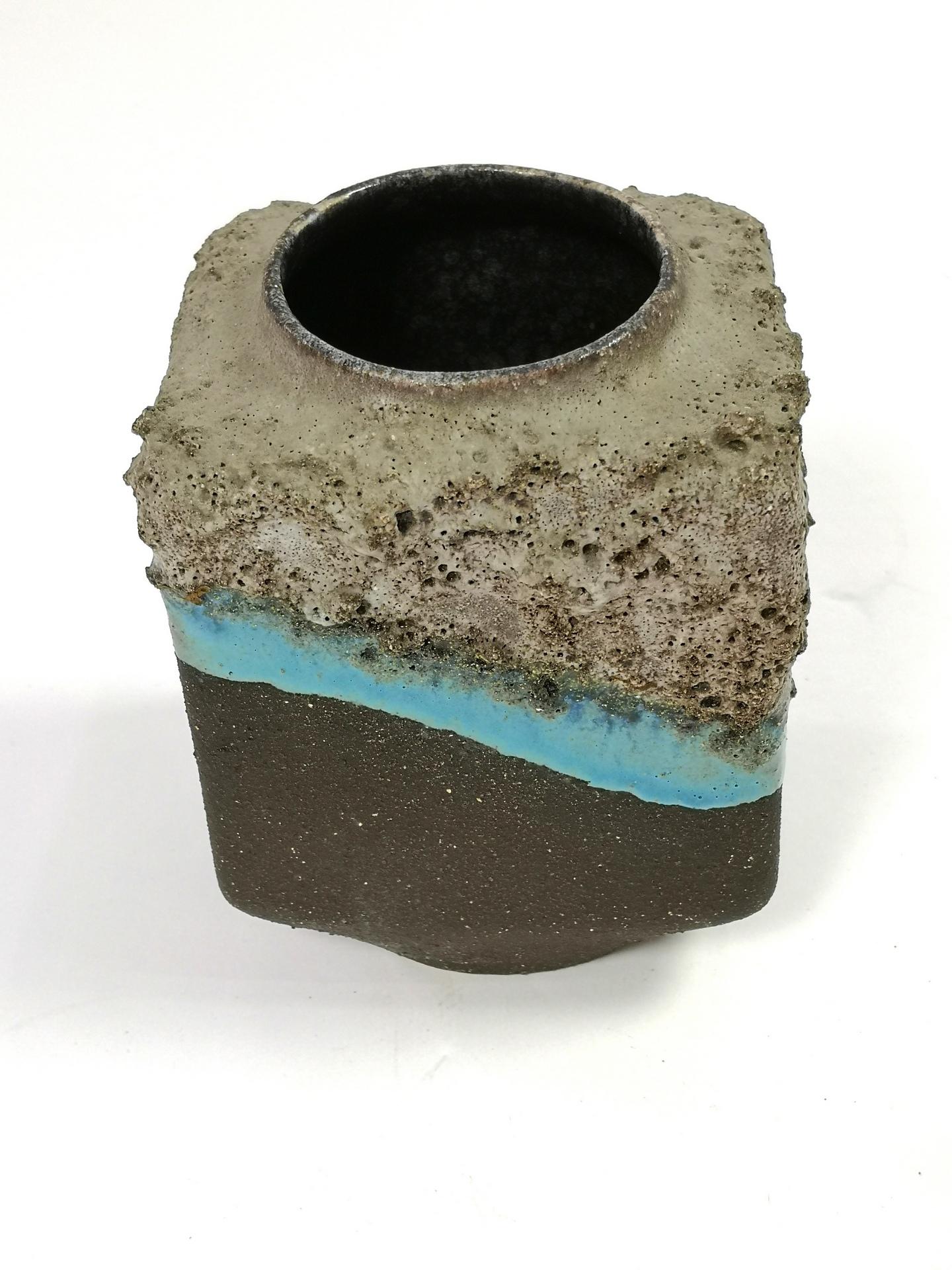 With turquoise glaze decor, this small hand made ceramic vase was made in the 1970's.