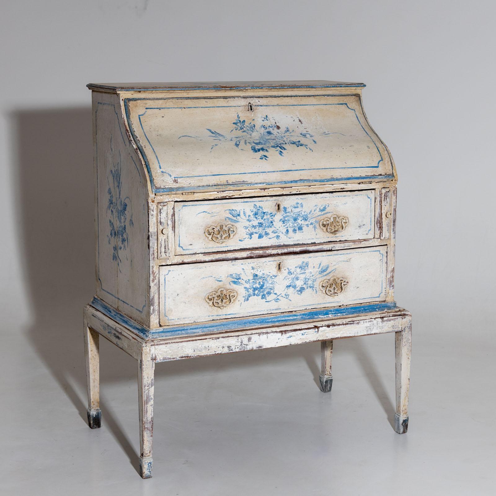 Small painted secretary with two drawers and curved sloping flap. The interior consists of letter compartments with ogival frames and low drawers. The cream white and light blue setting is new and features delicate floral bouquets on the surfaces.

