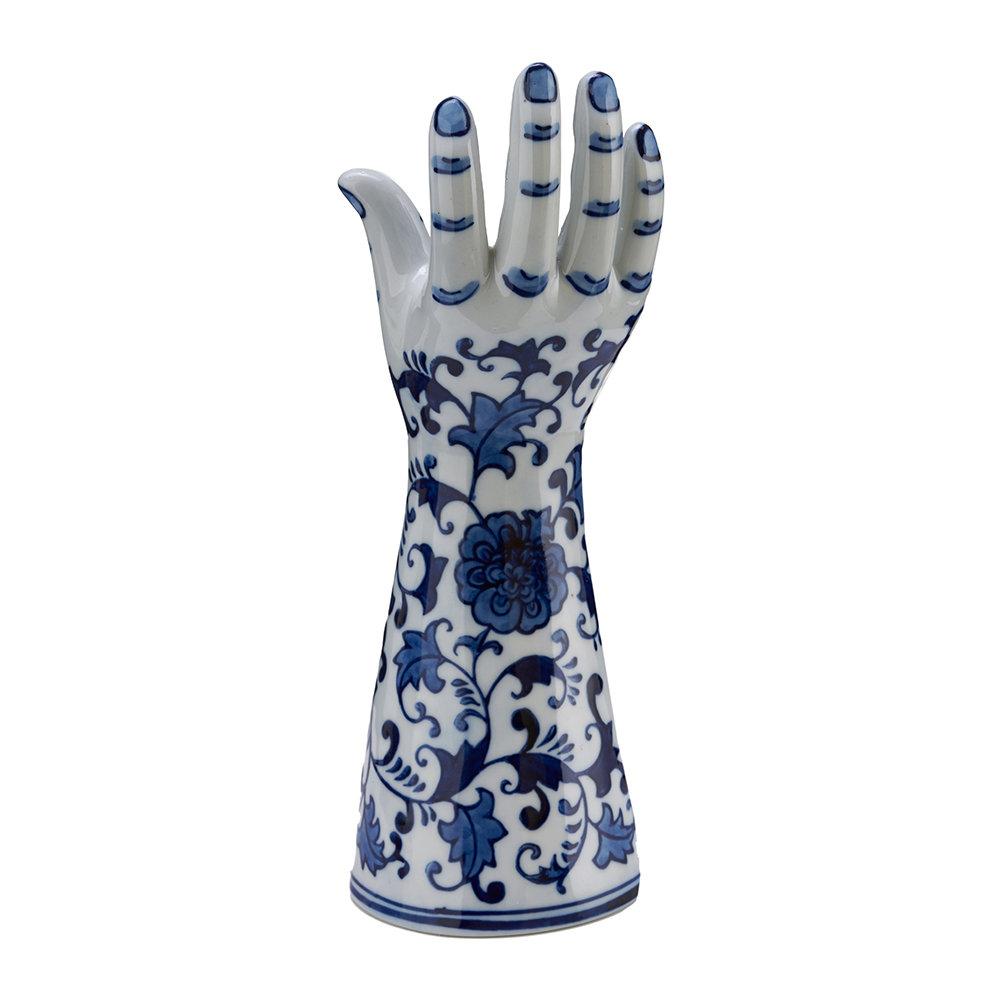 A candleholder in the shape of a human hand. This unique accessory is porcelain made with a glazed finish. A hand painted blue floral pattern wraps around the exterior. Holds one tapered candle. Crafted in the Netherlands. 

Measurements:

10” H