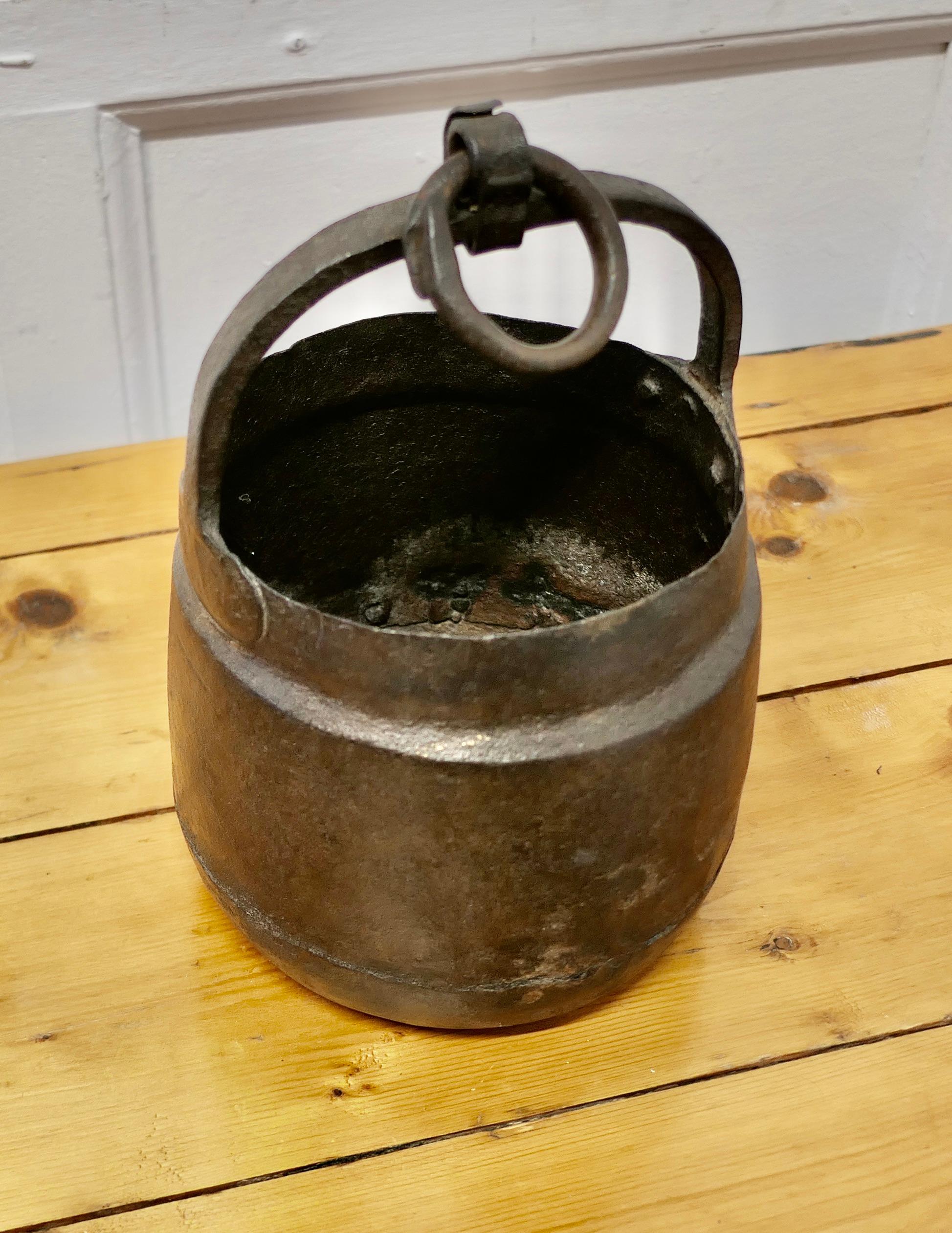 Small Heavy Hand Forged Iron Bucket 

This is a lovely small bucket, this charming piece has a rounded shape and   a hanging ring in the handle 
The cauldron is in good well aged condition, it is 8” in diameter and 10” high 
VY85