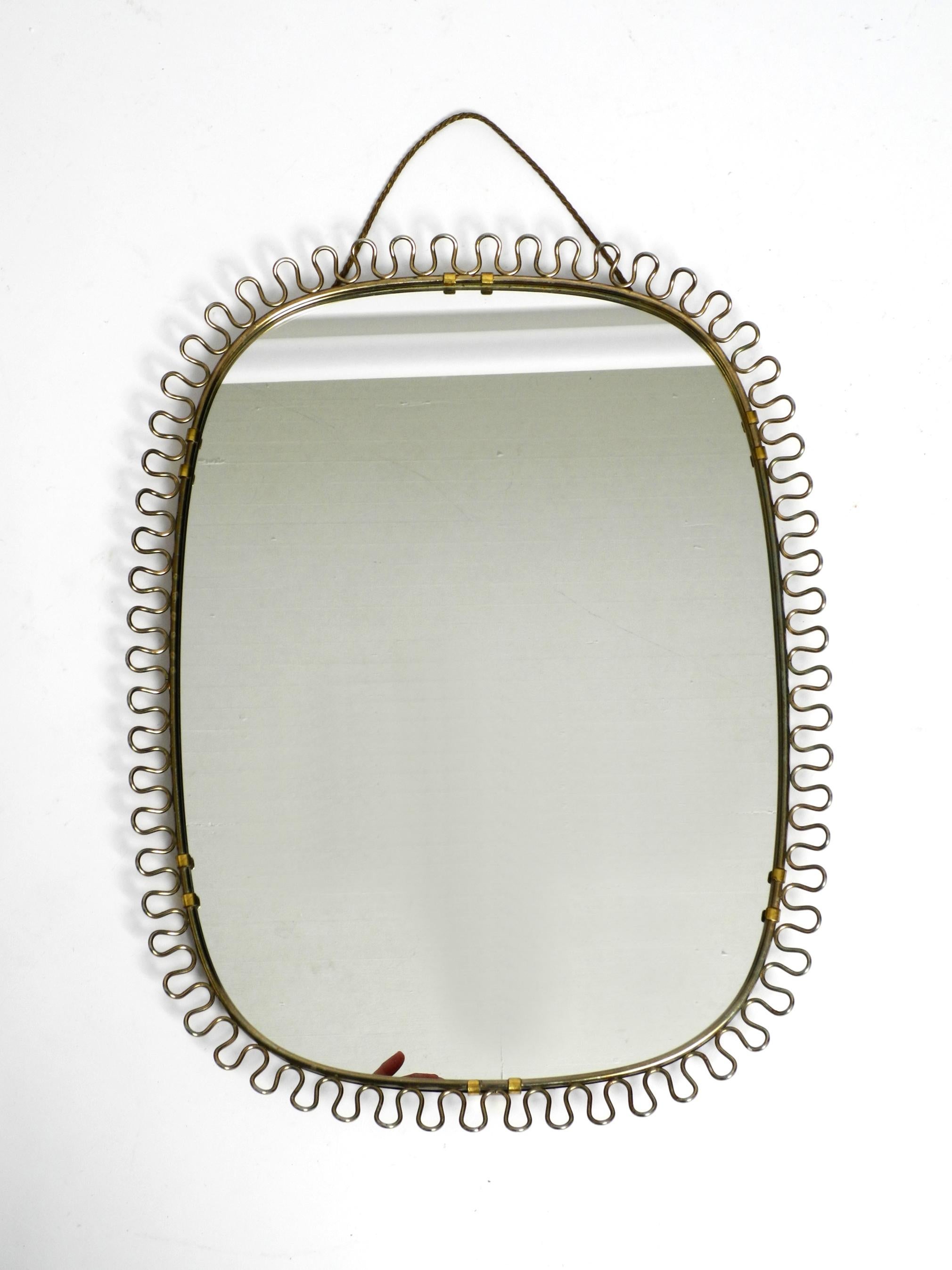 Small, heavy Mid Century wall mirror with a frame with gold colored metal loops For Sale 10