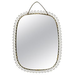 Small, heavy Mid Century wall mirror with a frame with gold colored metal loops